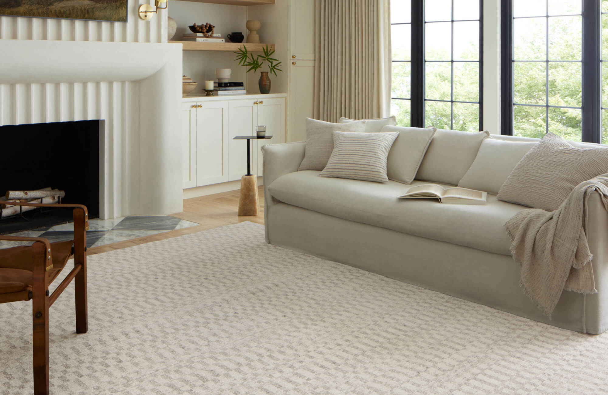 null Soft geometric rug in beige tones grounds the cozy, light-filled living room with layered textures and elegance.
