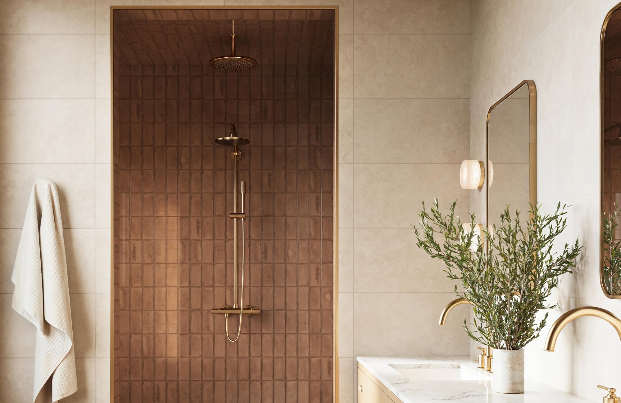 Shower with rich brown ceramic tile and brushed gold fixtures paired with soft beige walls and a modern marble vanity with gold faucets