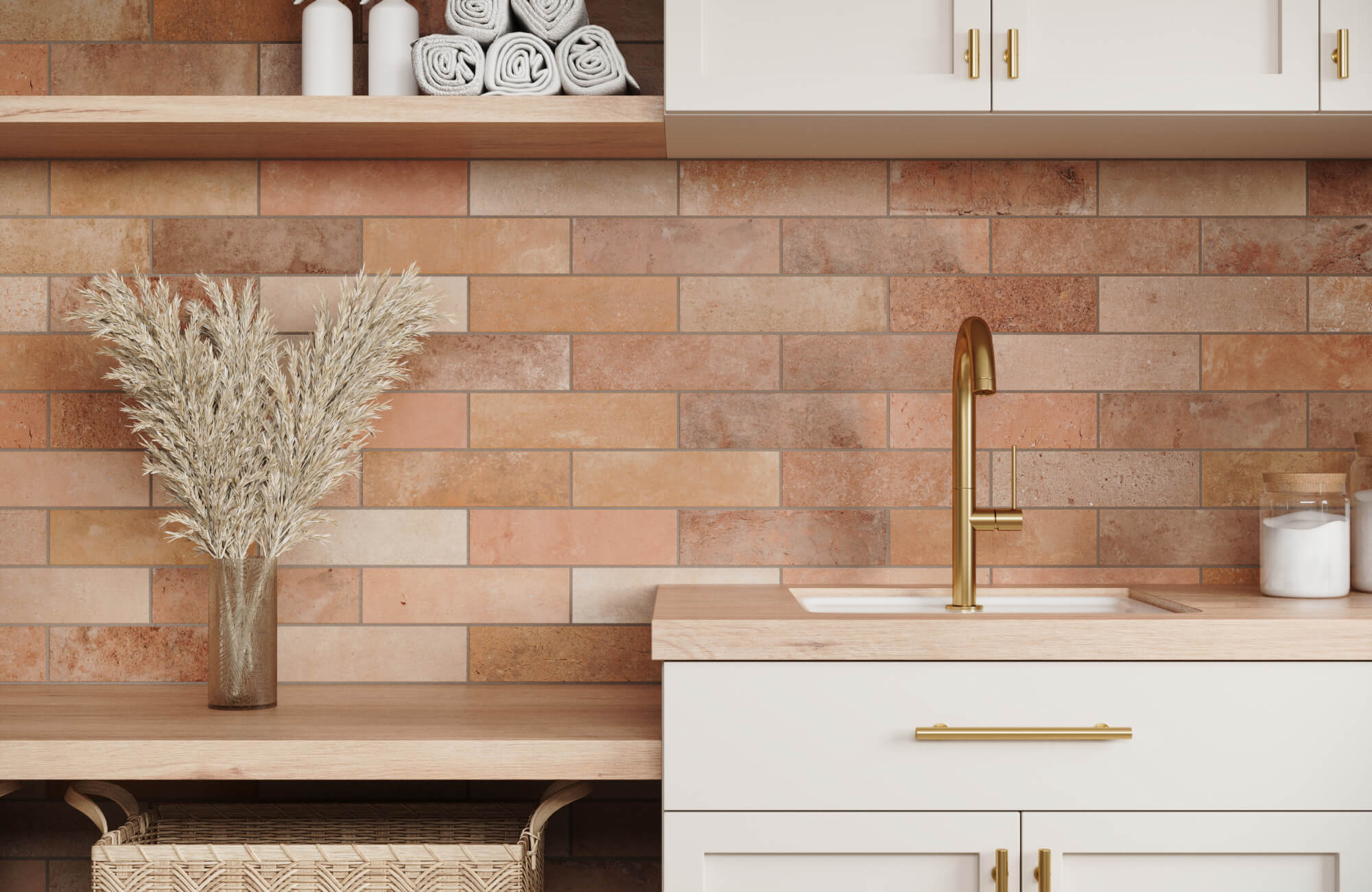 Laundry room with warm brown ceramic tile backsplash, matte gold faucet, white shaker cabinets, and light oak countertop accents