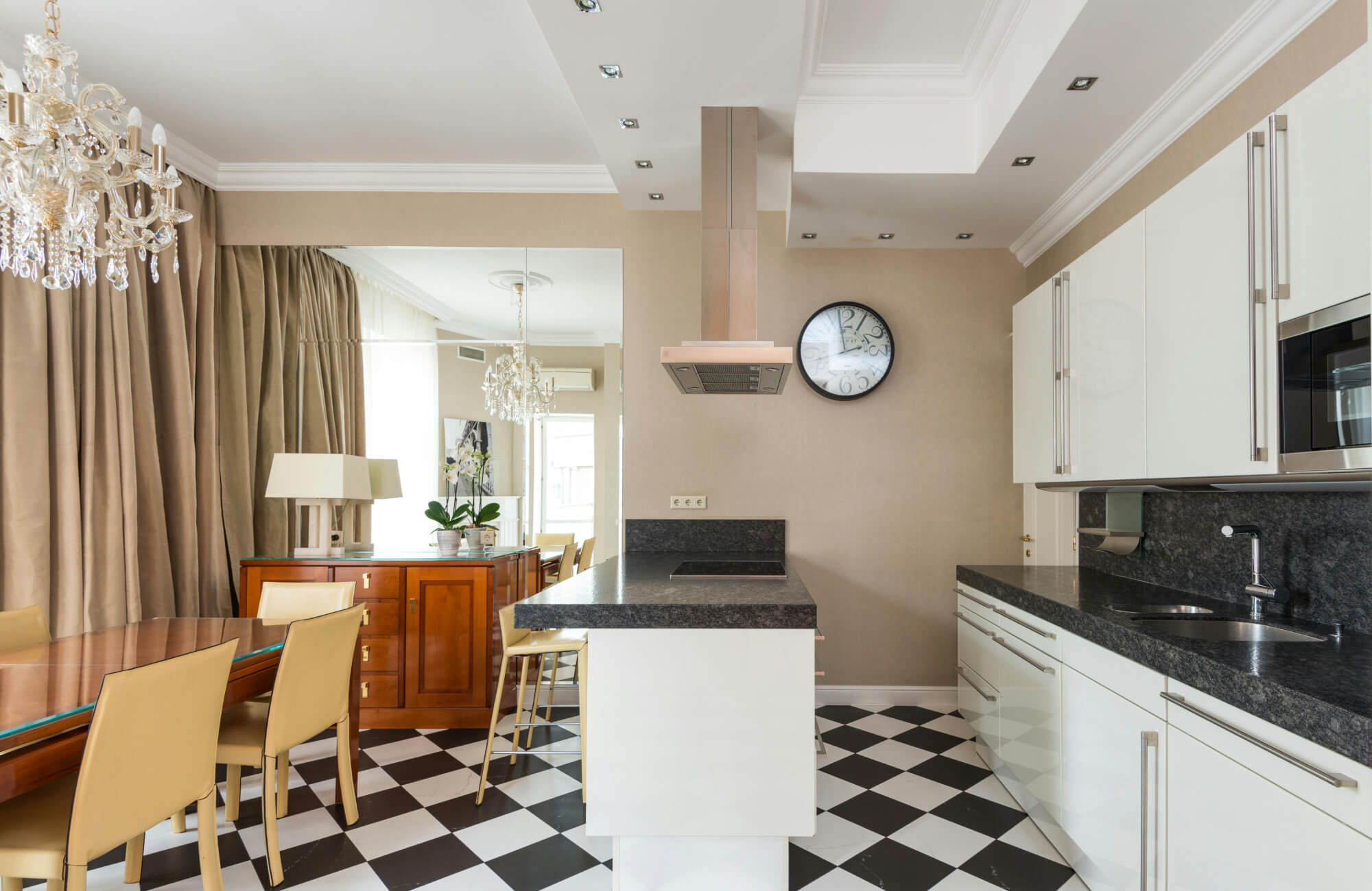 null Elegant kitchen with a black and white checkered floor, glossy white cabinetry, beige walls, and crystal chandeliers for a sophisticated touch.