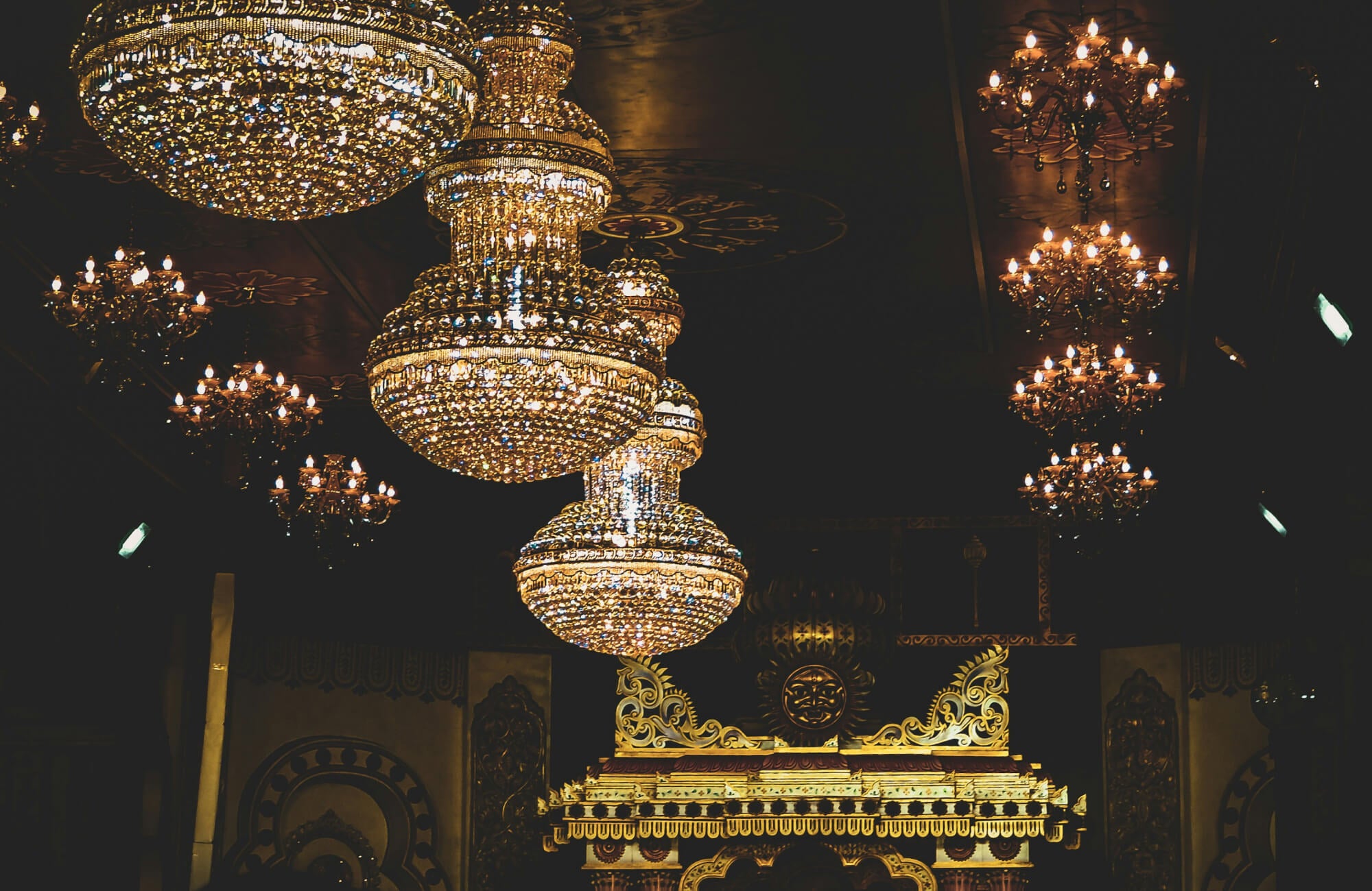 null Lavish hall adorned with multiple grand chandeliers, their shimmering crystals casting a golden glow over the intricately decorated interior.