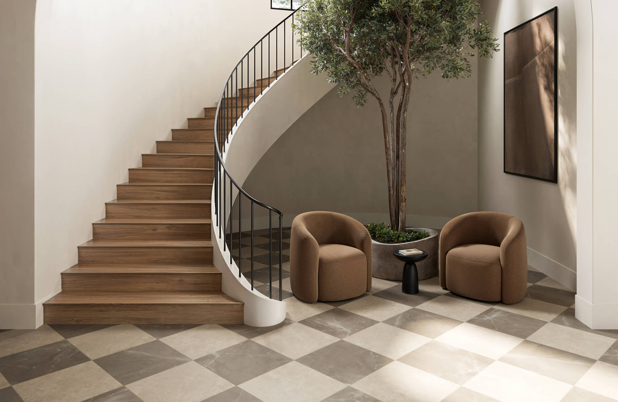 null Sophisticated entryway with a taupe and beige checkerboard marble floor, warm wood stairs, and plush modern seating.