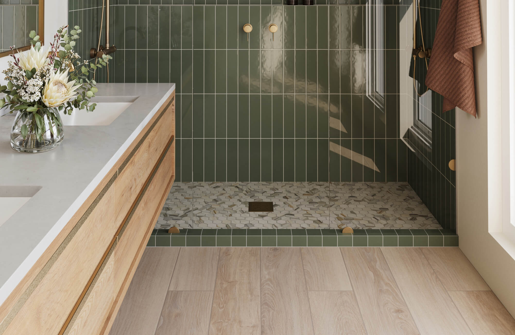 null Glossy moss green subway tiles accentuate a walk-in shower with a hex marble look mosaic shower floor tile, and light oak wood look plank flooring laid in a linear pattern, paired with a light wood vanity and floral arrangement.