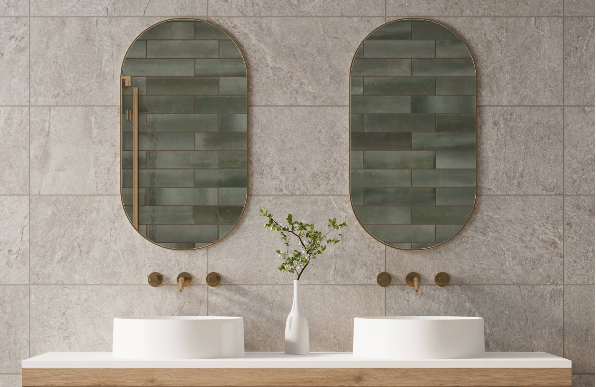 null Double sink vanity with brass faucets, oval mirrors, and a decorative branch in a white vase against large gray stone tiles.