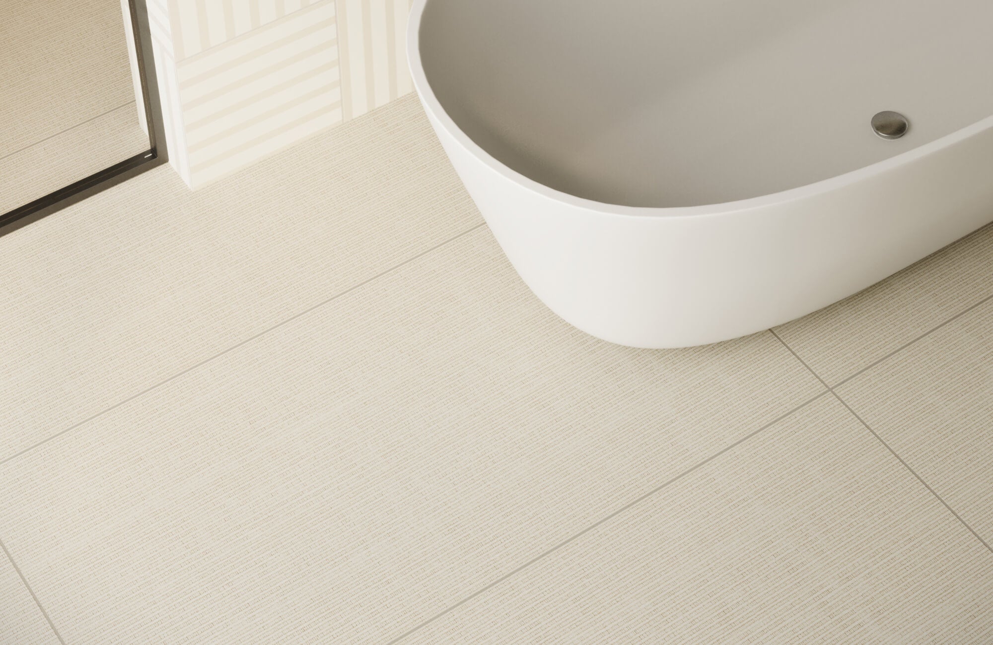 null Textured beige tiled bathroom floor with a curved white tub in a soft, neutral-toned setting.