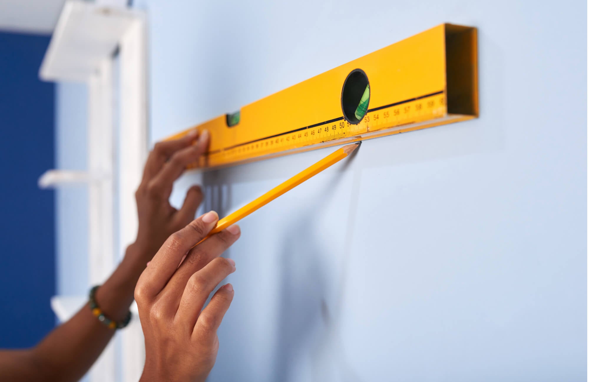 null Marking the wall with a pencil and level to test mirror height placement before installation for proper alignment and balance