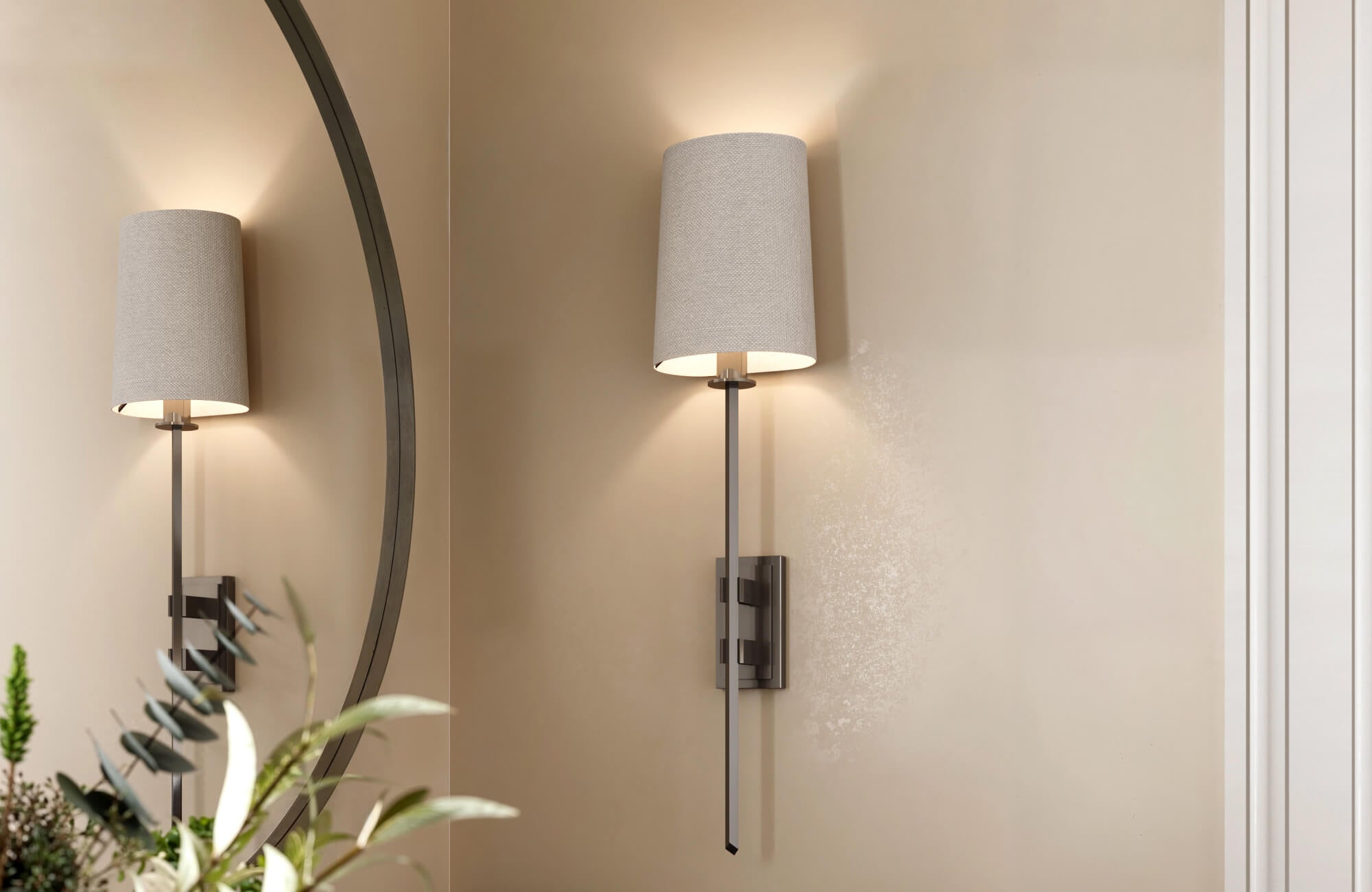 null Modern wall sconce with a tall fabric shade, reflecting soft illumination in a neutral-toned room.