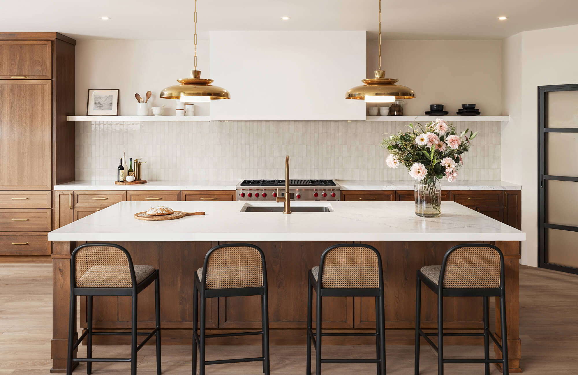 null Inviting kitchen with zellige-style backsplash, globe pendant lights, and rich wood cabinets with brass hardware.