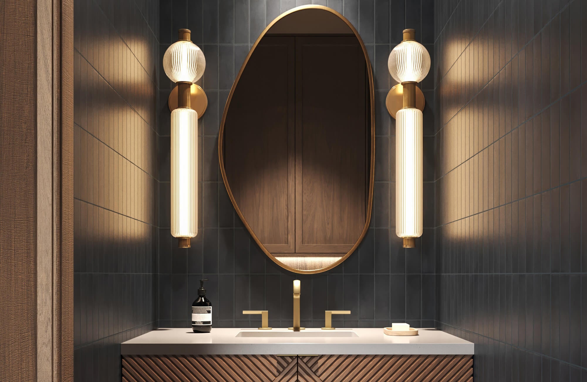 null Sophisticated bathroom with vertical matte black tiles, brass fixtures, and glowing sculptural sconces beside an oval mirror.