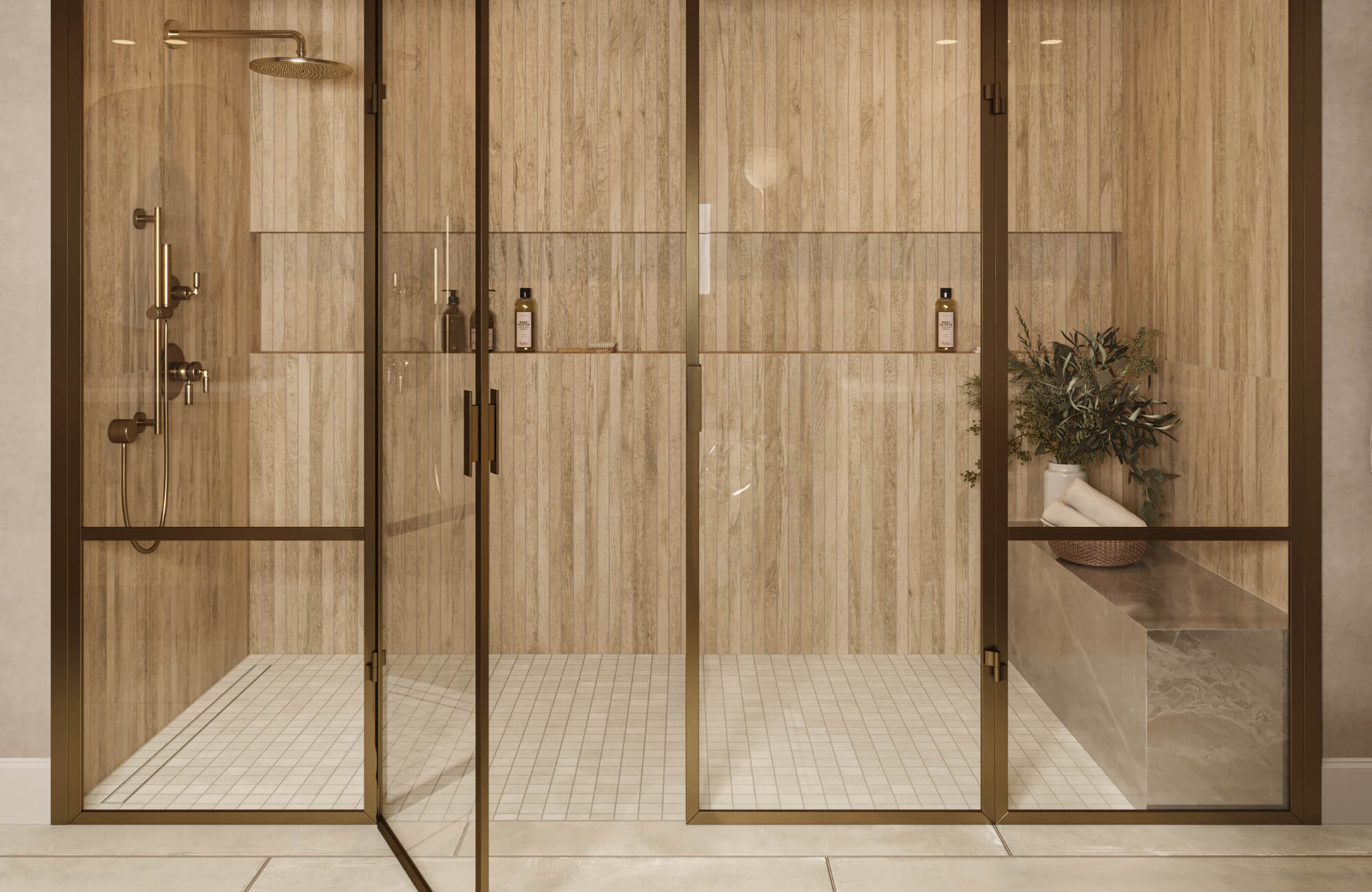 Glass-enclosed shower with white 2x2 mosaic tile floor, wood-look wall tiles, bronze fixtures, and built-in bench with decor accents.