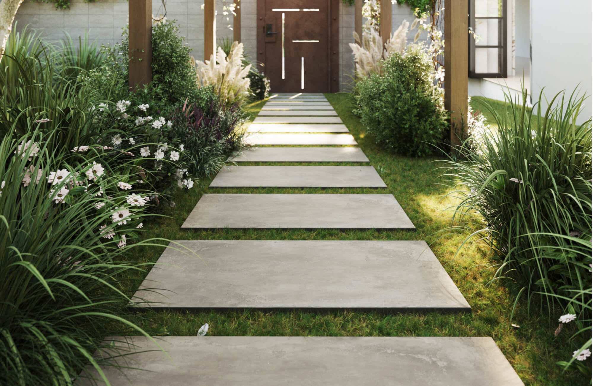 A serene garden walkway features large rectangular outdoor tile stepping stones set over soft grass, bordered by lush ornamental plants and leading toward a modern wooden entry door.