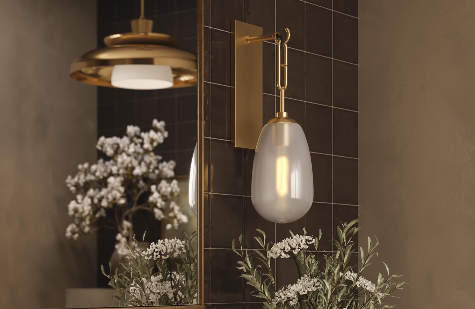 null Close-up of a modern brass wall sconce with a frosted glass shade beside a mirror, accented by dark tiles and white flowers.