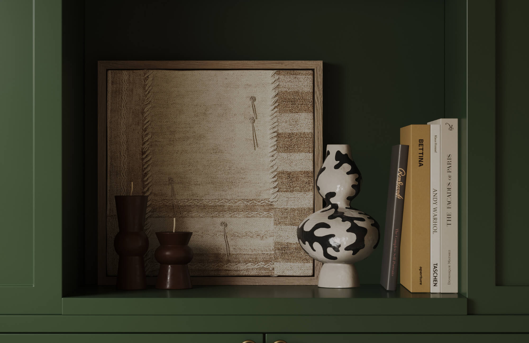 null Styled shelf with framed textile artwork, sculptural vase, and books against deep green cabinetry, creating a curated and intimate display.