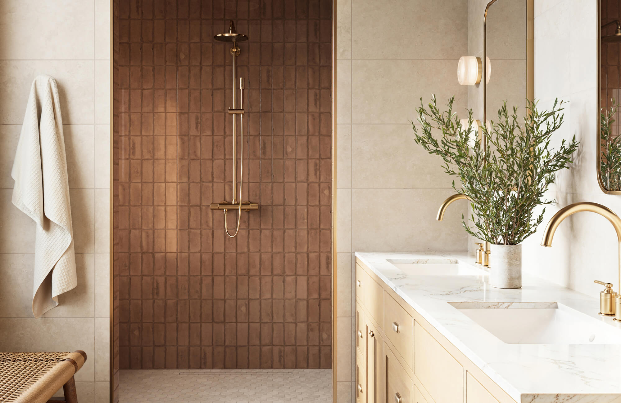 null Modern bathroom with vertical brown subway tiles in the shower, gold fixtures, and a double vanity with marble countertop and greenery.