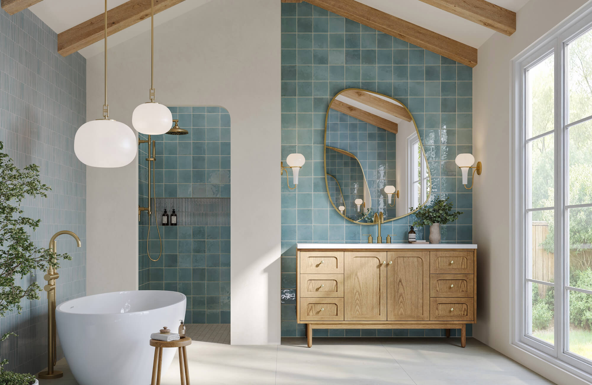 Bright bathroom with a stylish wooden vanity and a large organic-shaped bathroom mirror framed in gold, set against glossy teal tiles for a serene modern look.