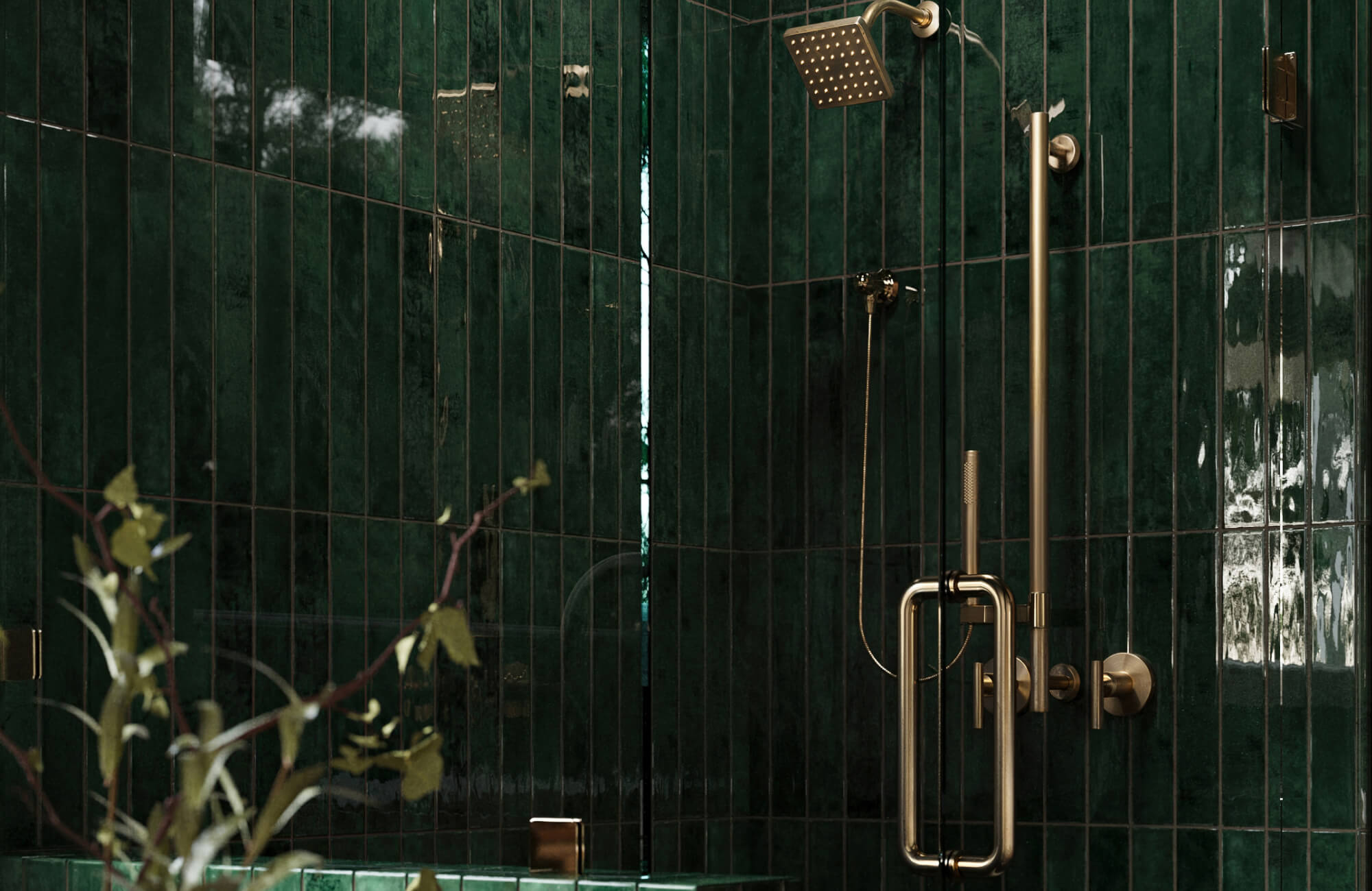 Dark green glossy tile shower with brass fixtures, glass enclosure, and dramatic lighting creating a rich spa-inspired bathroom design.