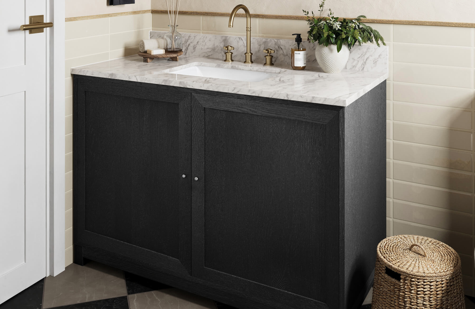 Bathroom with black wood vanity cabinet and marble countertop featuring brass faucet, cream tile backsplash, and checkered floor tile