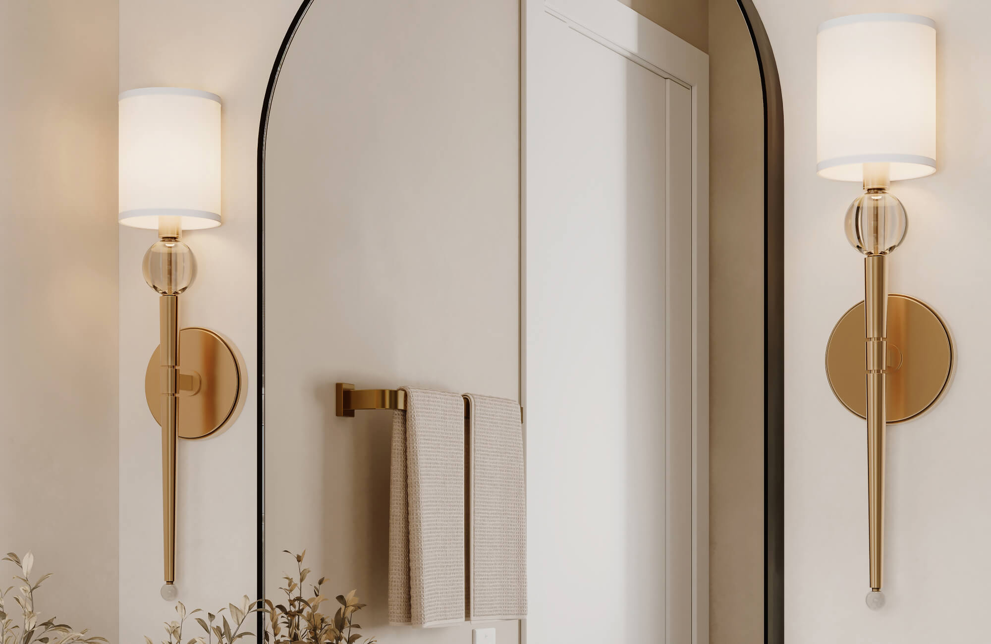 null Elegant brass wall sconces with glass accents flank an arched mirror in a softly lit modern bathroom.
