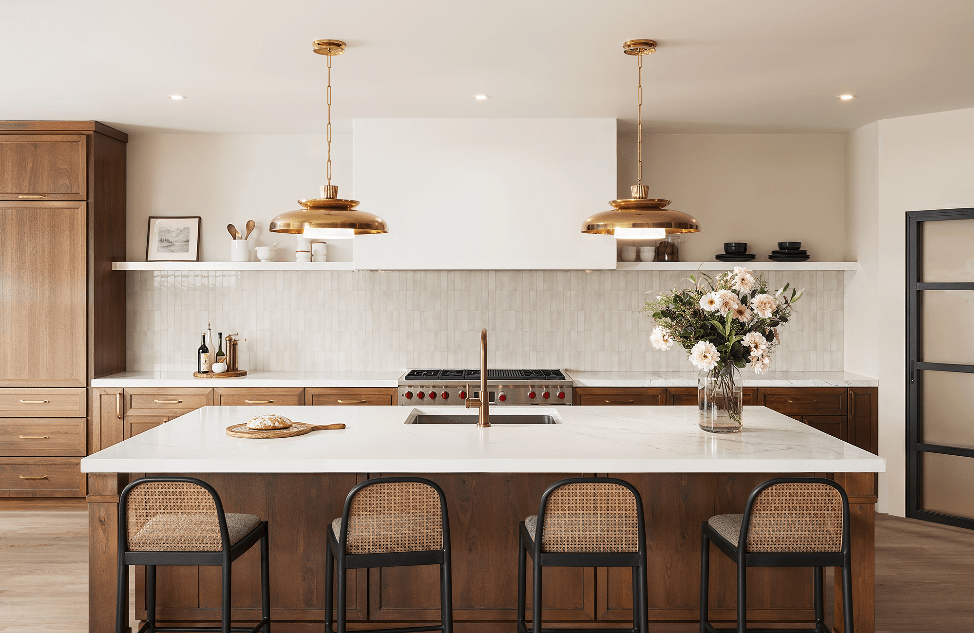 null Modern kitchen with creamy square tile backsplash, walnut cabinetry, and brass pendant lighting.