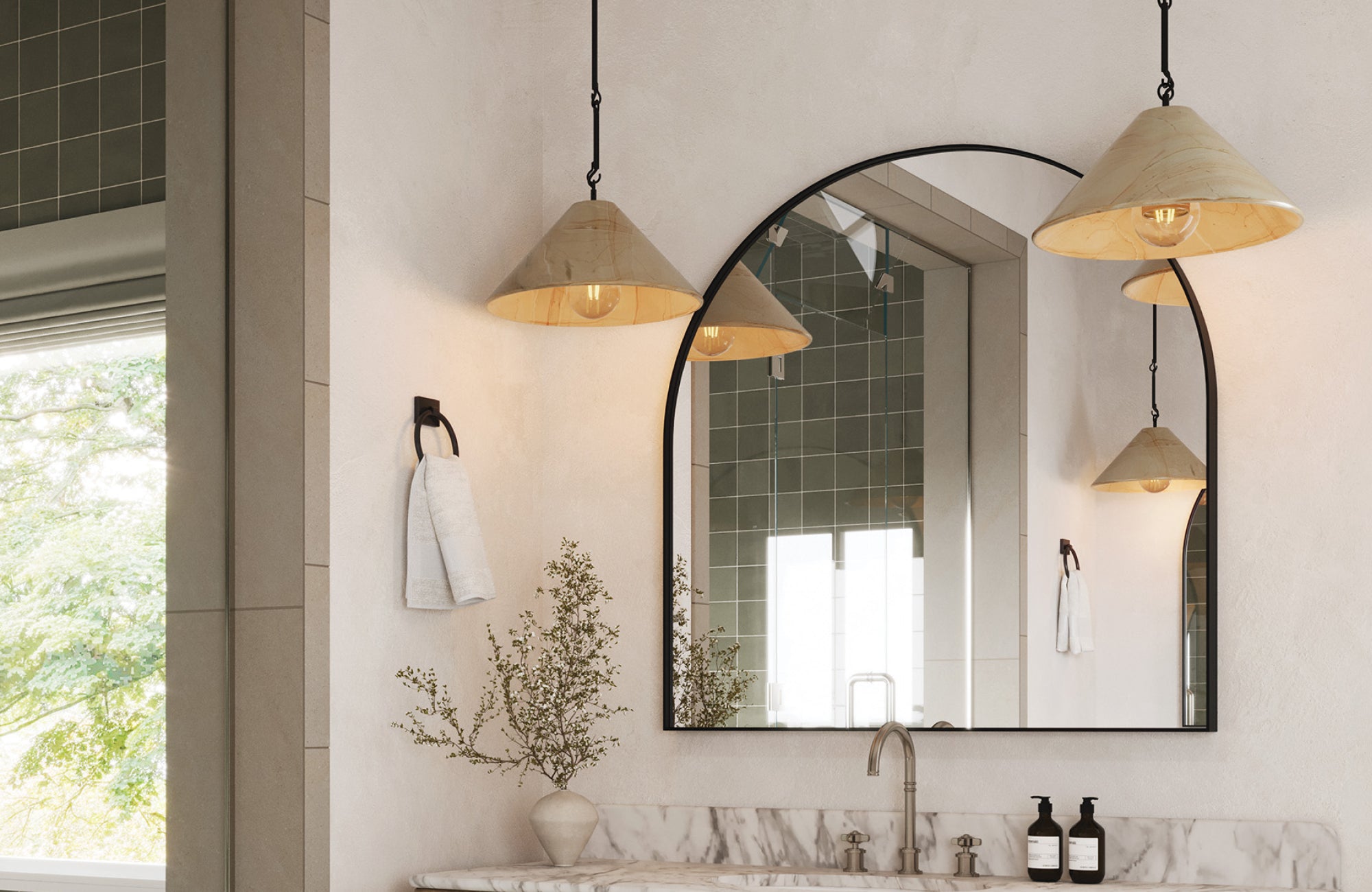 null Cone-shaped pendant lights hang over a marble vanity with an arched mirror in a soft-toned, naturally lit bathroom.