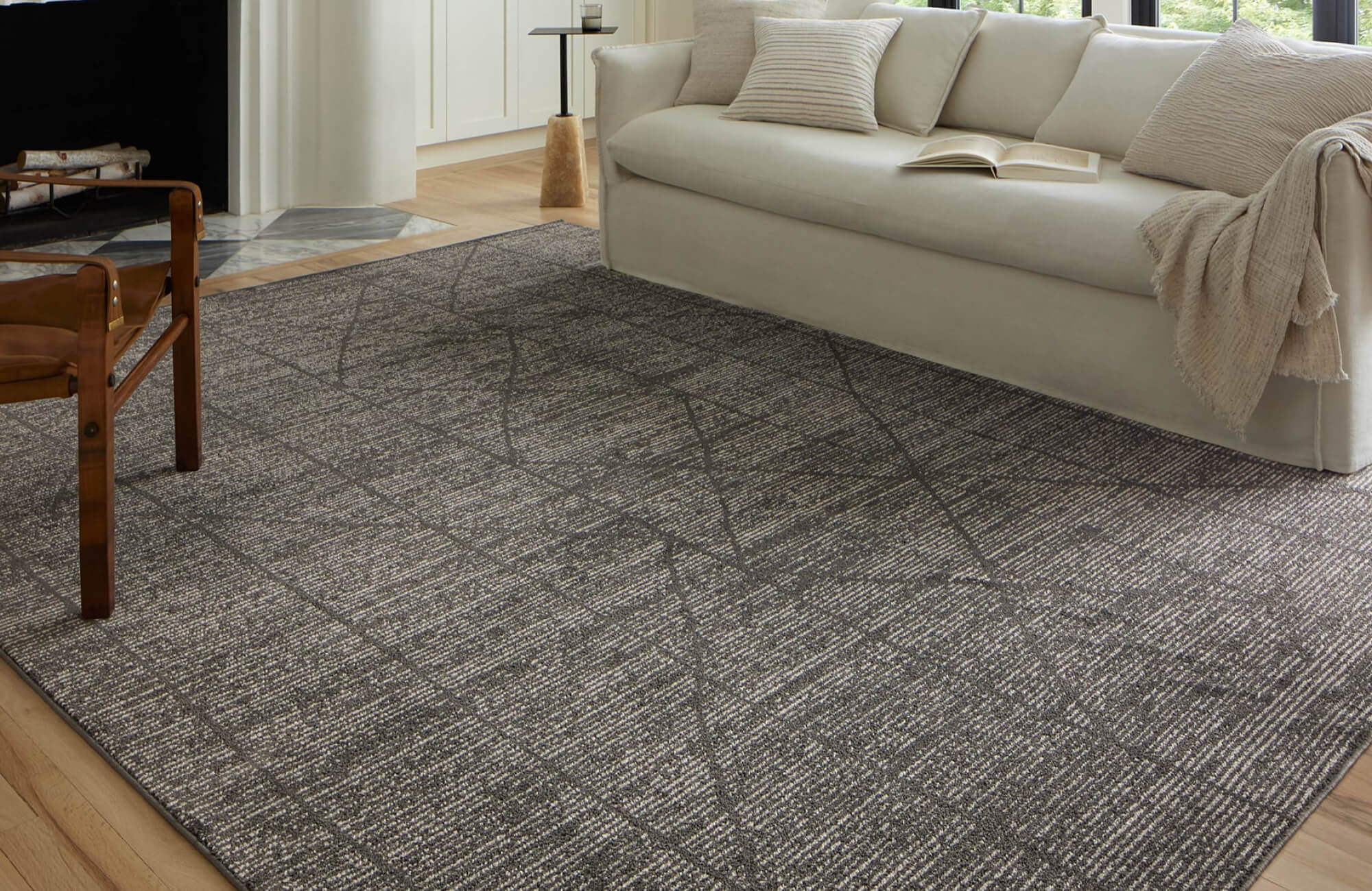 Contemporary Moroccan-inspired rug with subtle linear patterns in charcoal and ivory, grounding a modern neutral-toned living space.