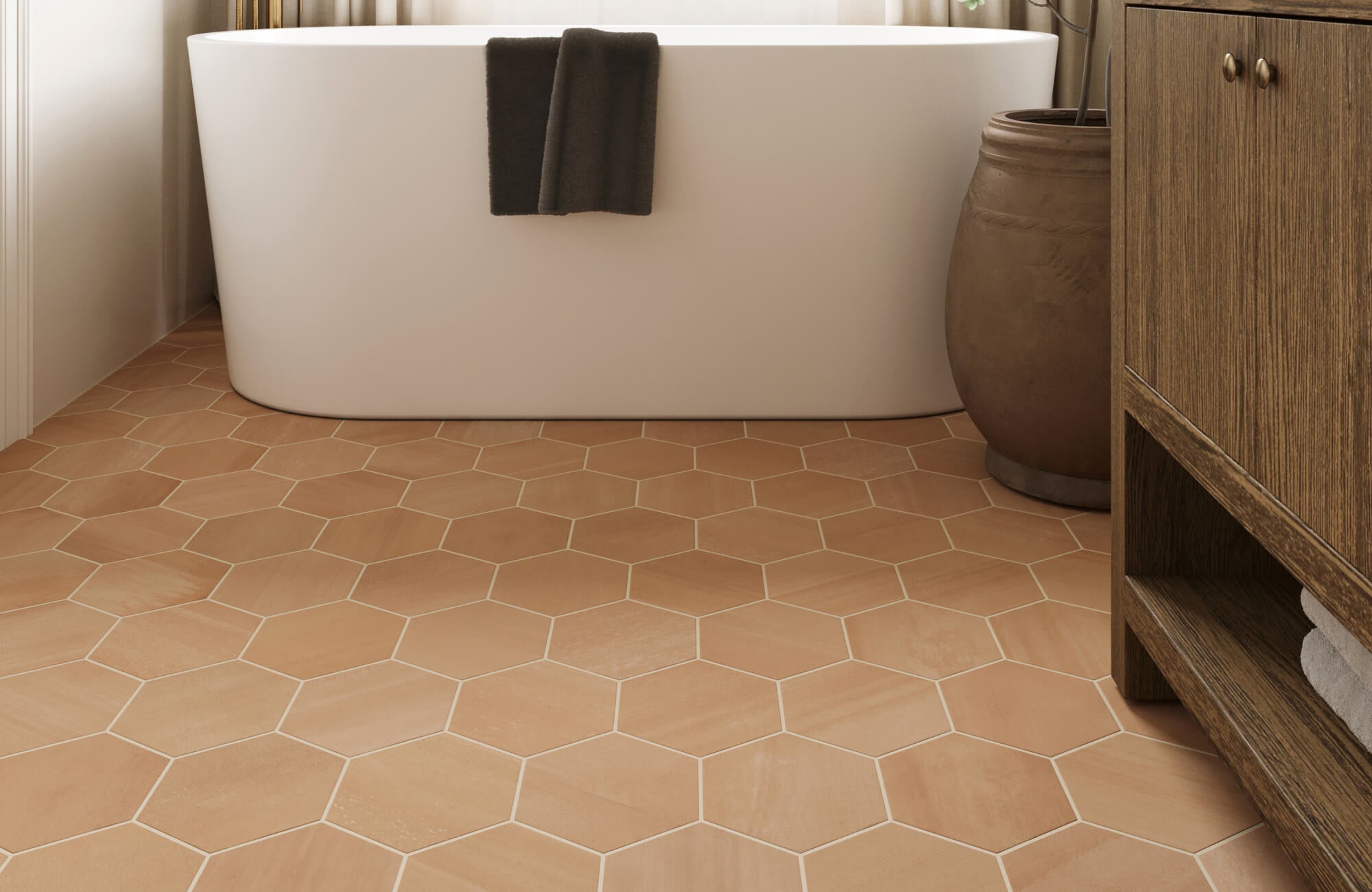 Matte terracotta hexagon tiles add warmth and texture to this modern bathroom with a freestanding white tub.