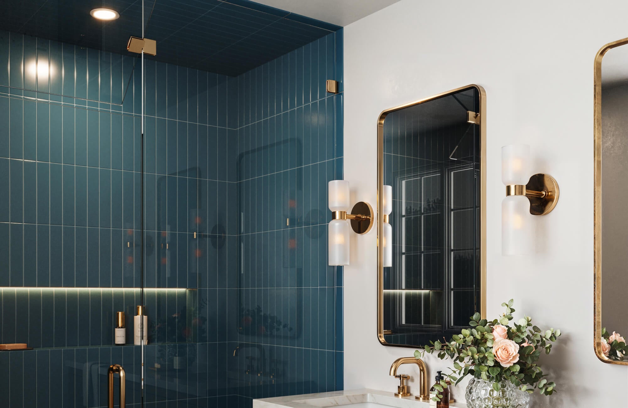 null Deep blue tiles cover the bathroom walls, pairing with a blue vanity, white sinks, and a freestanding tub for a rich, layered look.