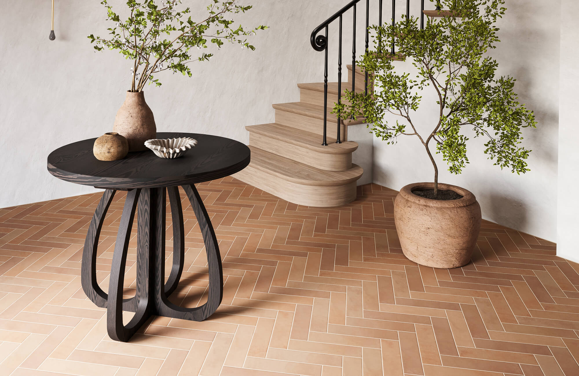null Warm terracotta subway tile floor in herringbone pattern paired with light wood staircase, black railing, and minimalist entry table with natural decor.