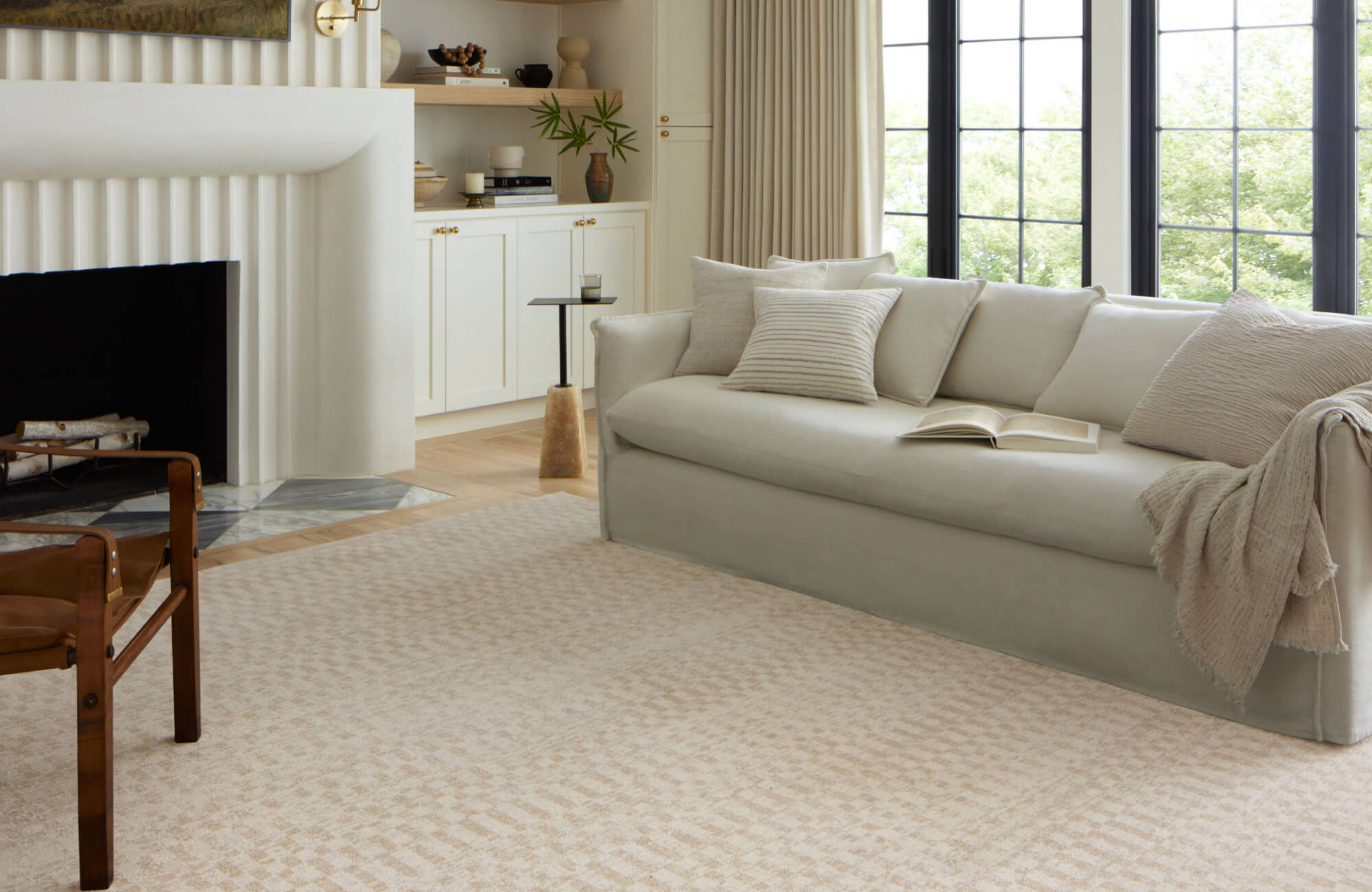 null Serene living room with a soft beige sofa, textured throw pillows, and a subtle checkered cream-toned rug.
