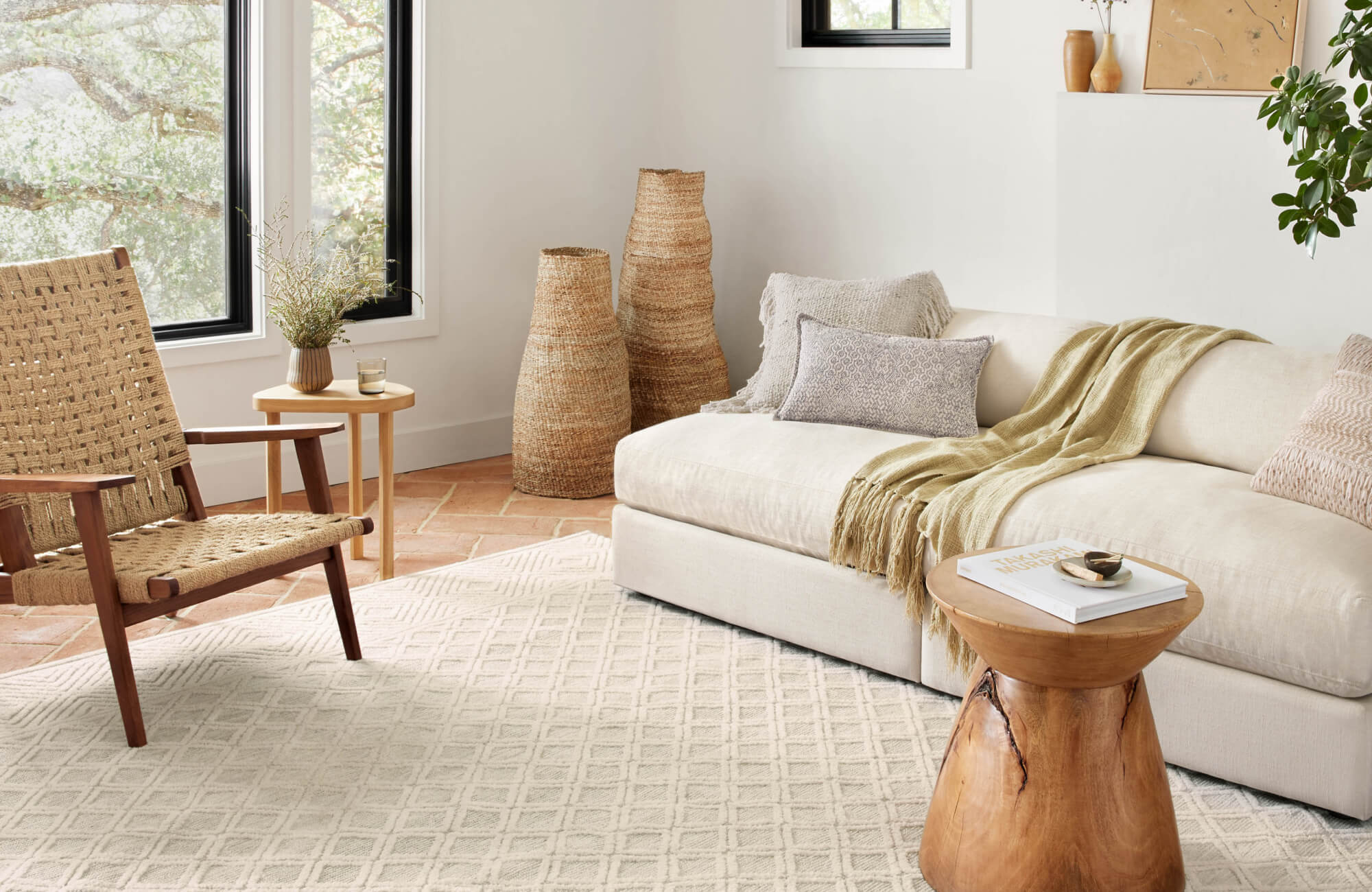 null Boho-inspired living room with cream diamond-pattern rug, woven lounge chair, and neutral-toned sectional.