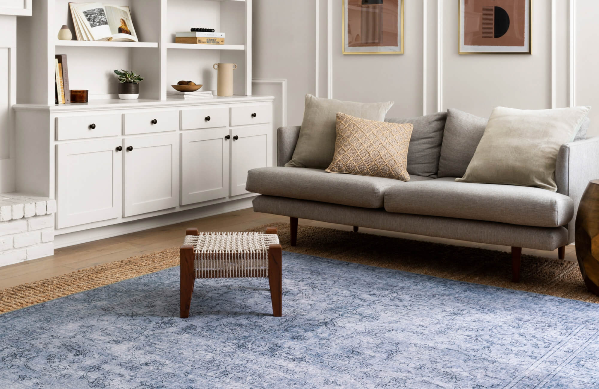 null Elegant living room with a soft blue vintage-style rug, mid-century gray sofa, and layered natural textures.