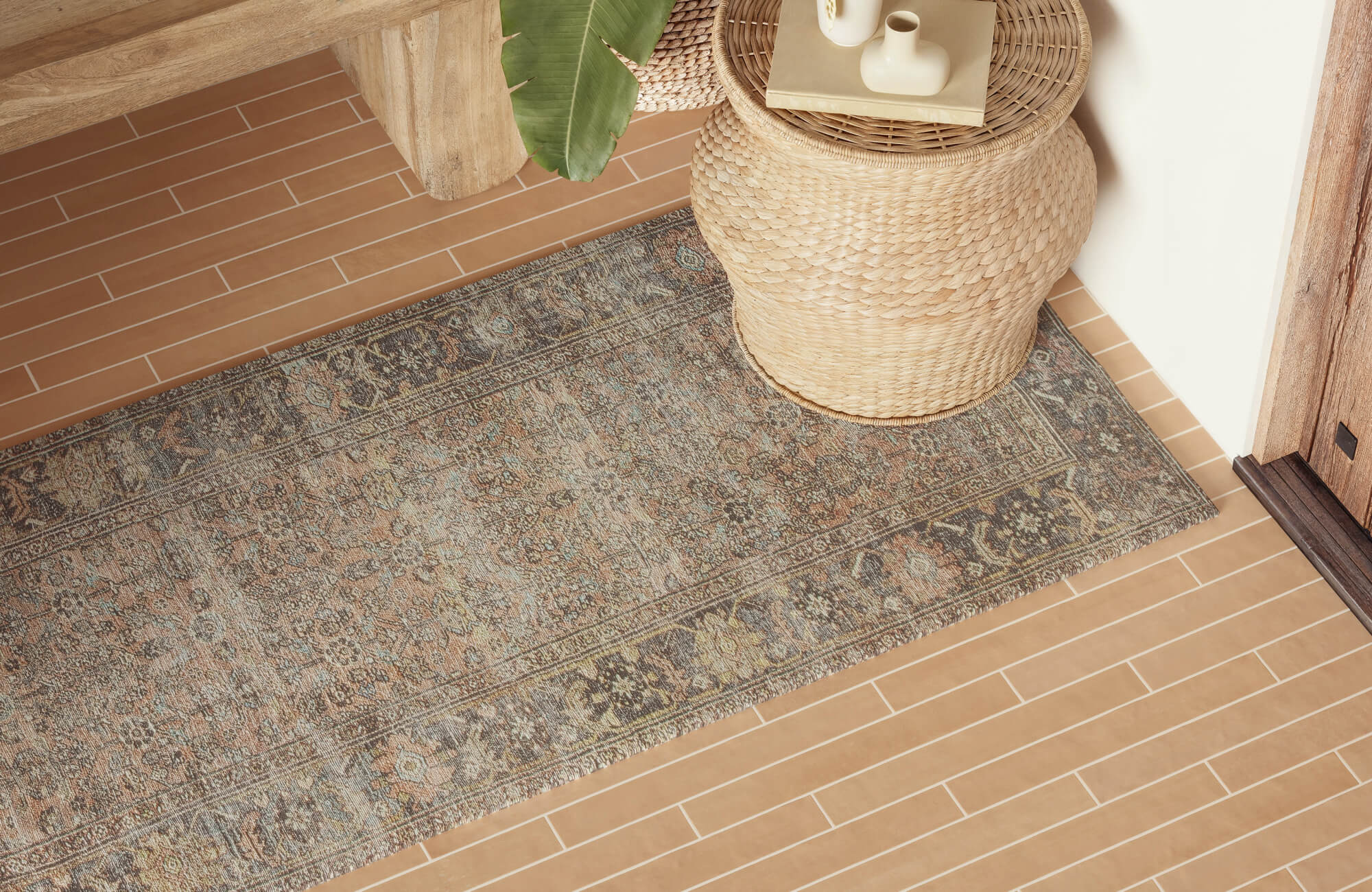 Beige and gray vintage-look runner rug styled in a modern utility space with shaker cabinets, farmhouse sink, and geometric tile floor.