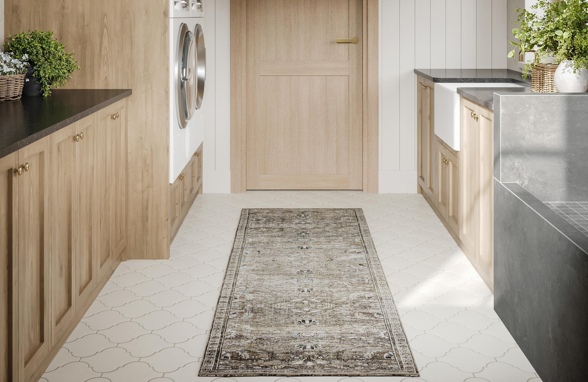 Muted vintage-style runner rug centered in a bright laundry space with built-in washer, farmhouse sink, and decorative tile floor.