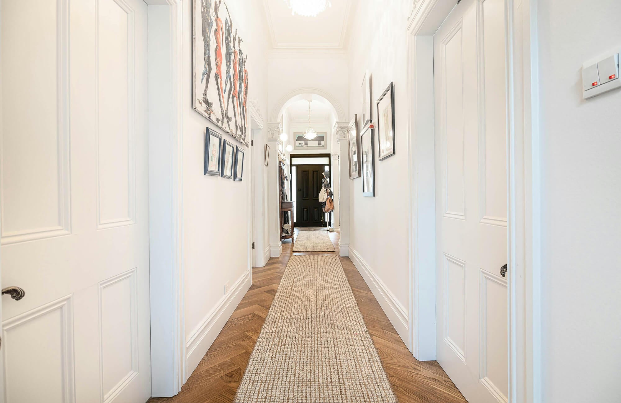 null Extended hallway runner rug, proportioned to fit the full length of the entry while leaving borders of the wood floor exposed.