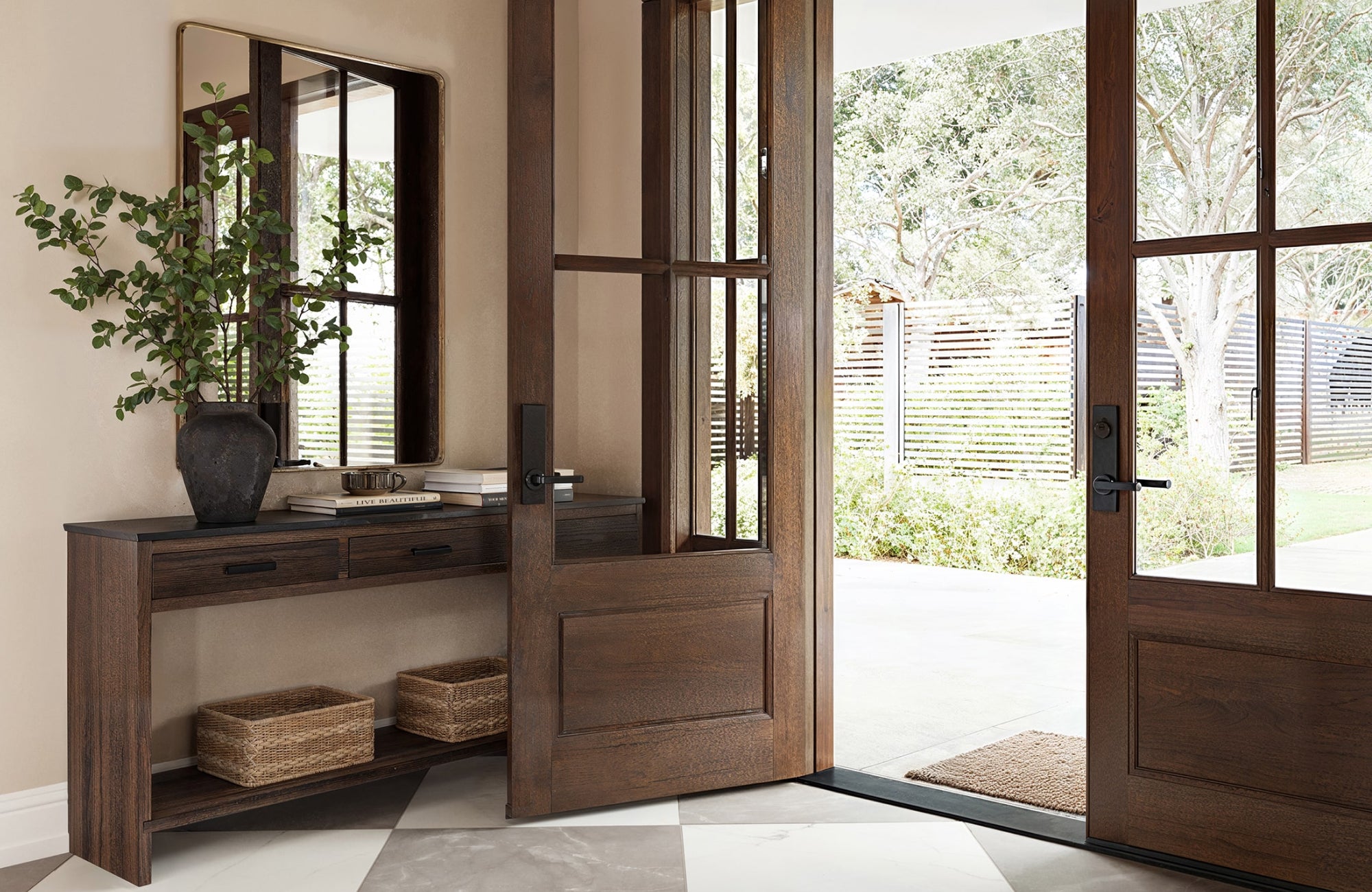 Rectangular mirror with rounded edges above a wooden console, complementing natural light from the doorway.