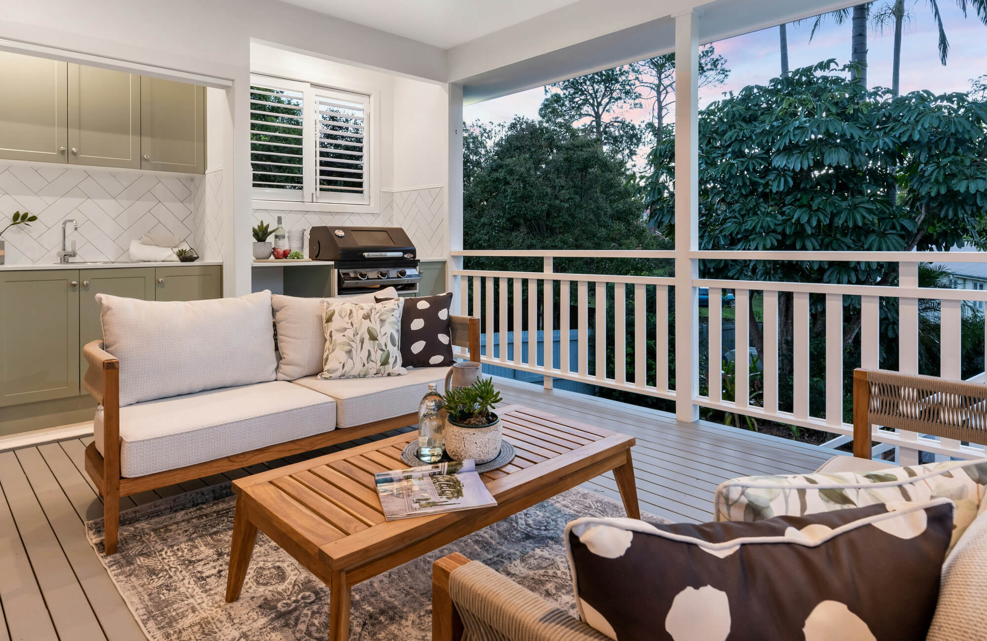 null Chic outdoor patio with wooden furniture, patterned cushions, and a weather-resistant polypropylene rug enhancing the cozy, nature-filled setting.