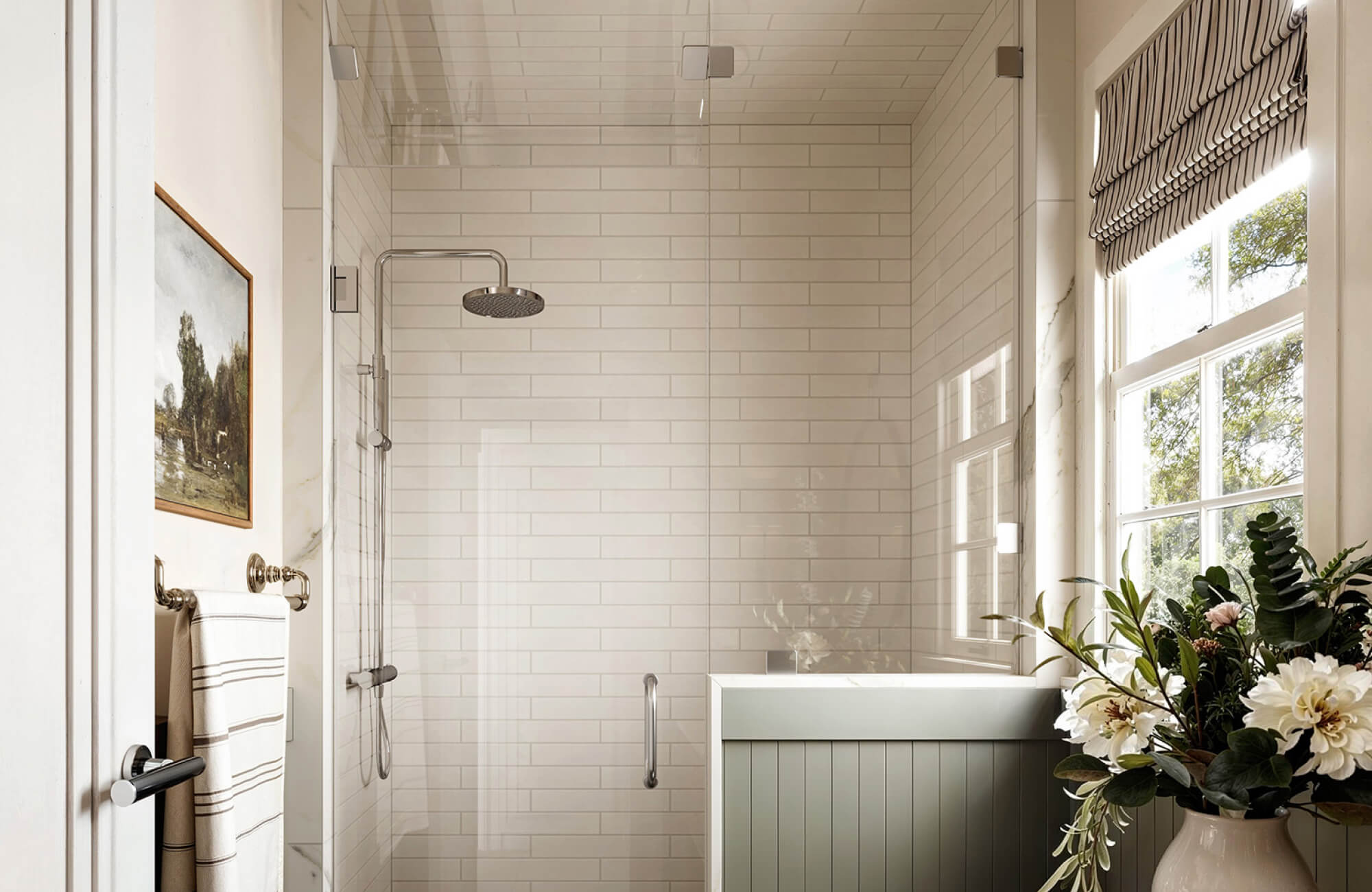 Soft off-white subway shower tiles paired with natural light create a bright look while gentle undertones soften streak visibility.