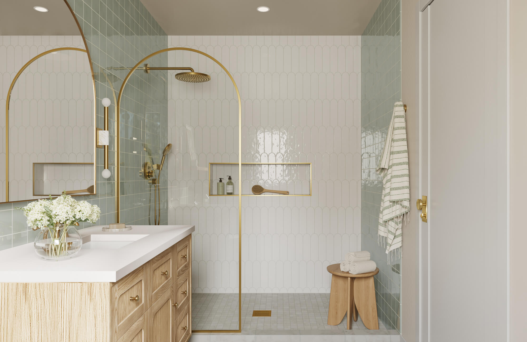 Glossy white scalloped tiles and soft green square tiles elevate this airy bathroom with a luxe gold shower frame.