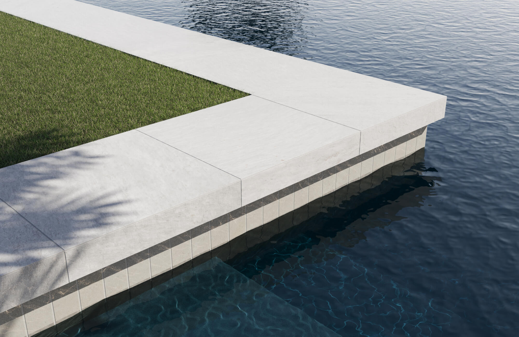 null Elegant pool edge with ivory stone coping and vertical cream tiles accented by a dark marble stripe, beside manicured grass.