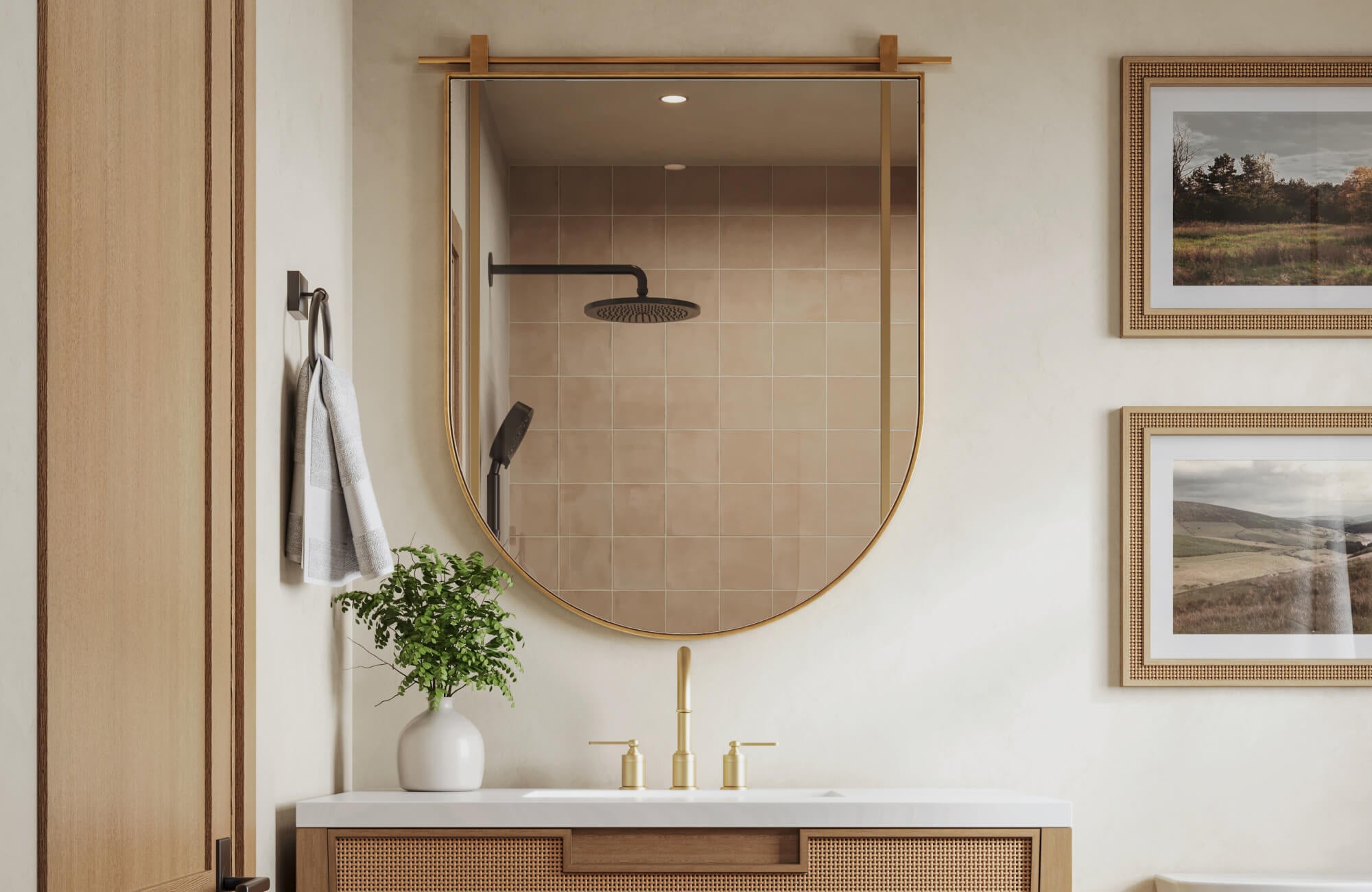 null Warm neutral bathroom with soft beige square tiles, brass fixtures, and a half-oval mirror above a rattan-accented vanity.