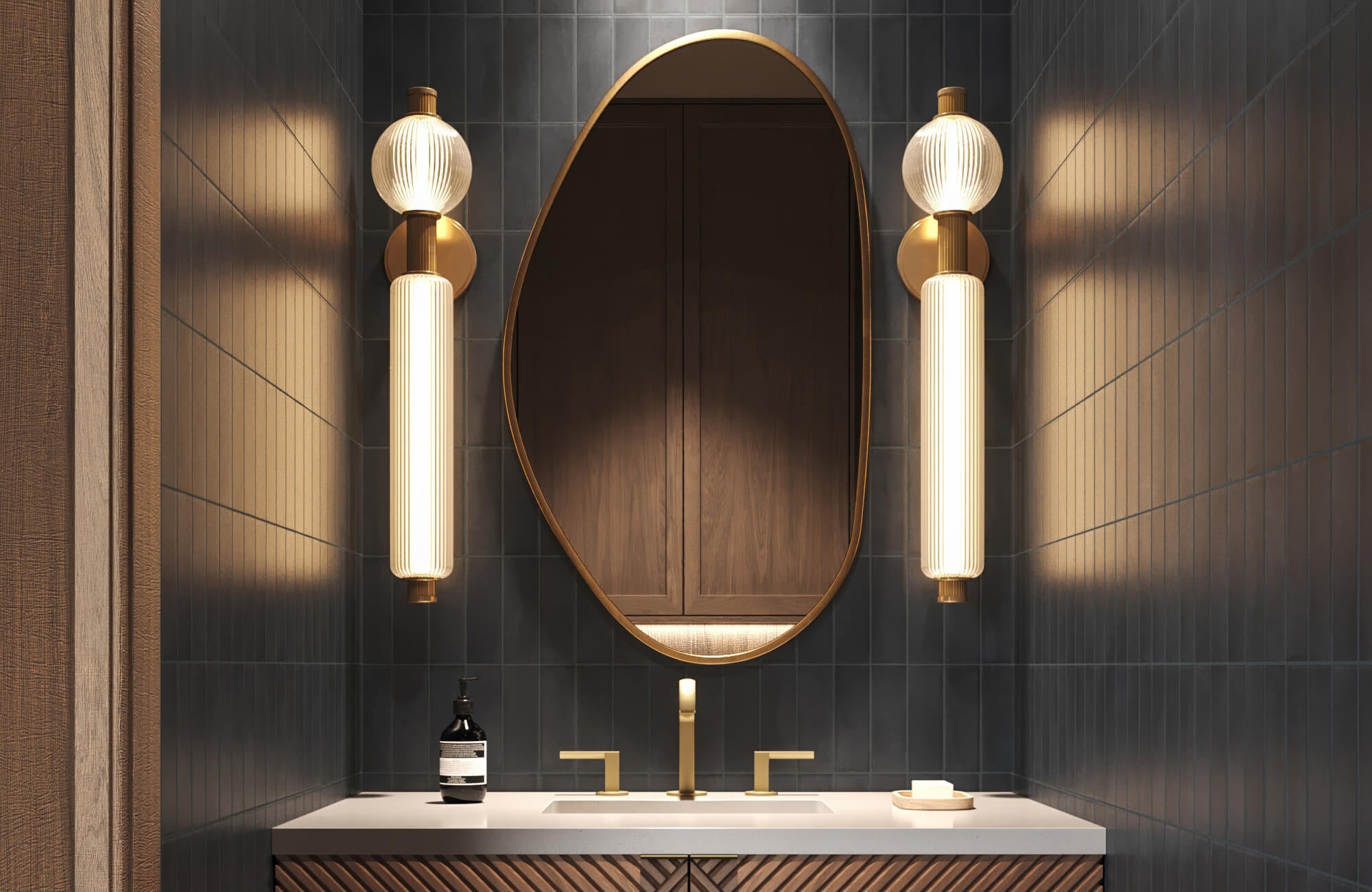 null Moody bathroom with deep navy vertical tiles, sculptural brass lighting, and an organic oval mirror above a fluted wood vanity.