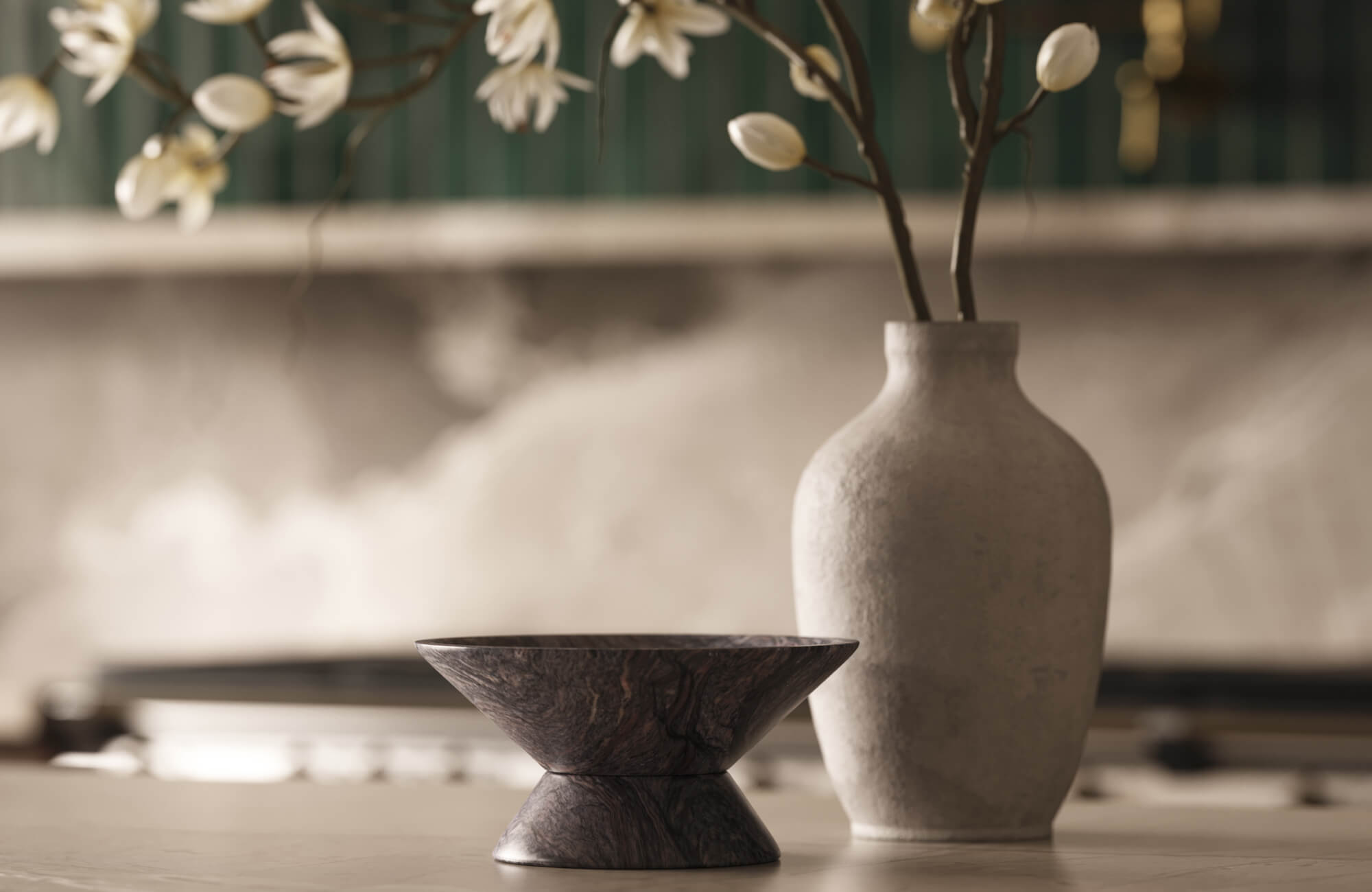 Positioned on the countertop, a decorative bowl with a pedestal base introduces natural warmth and visual depth, complementing the soft textures and floral arrangement nearby.