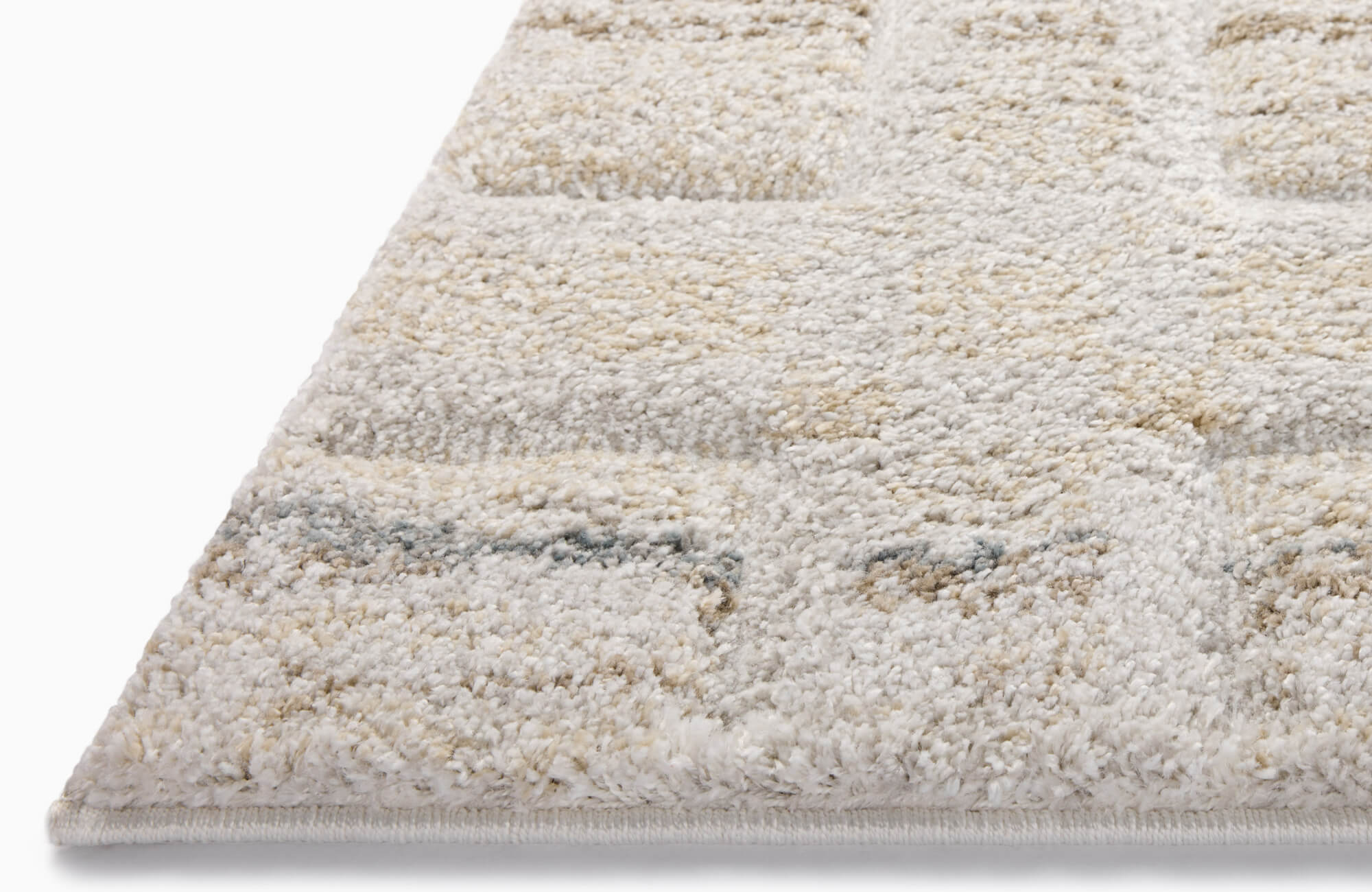 Soft patterned area rug with floral motifs in blue, rust, and beige tones being vacuumed, showing texture and pile movement.