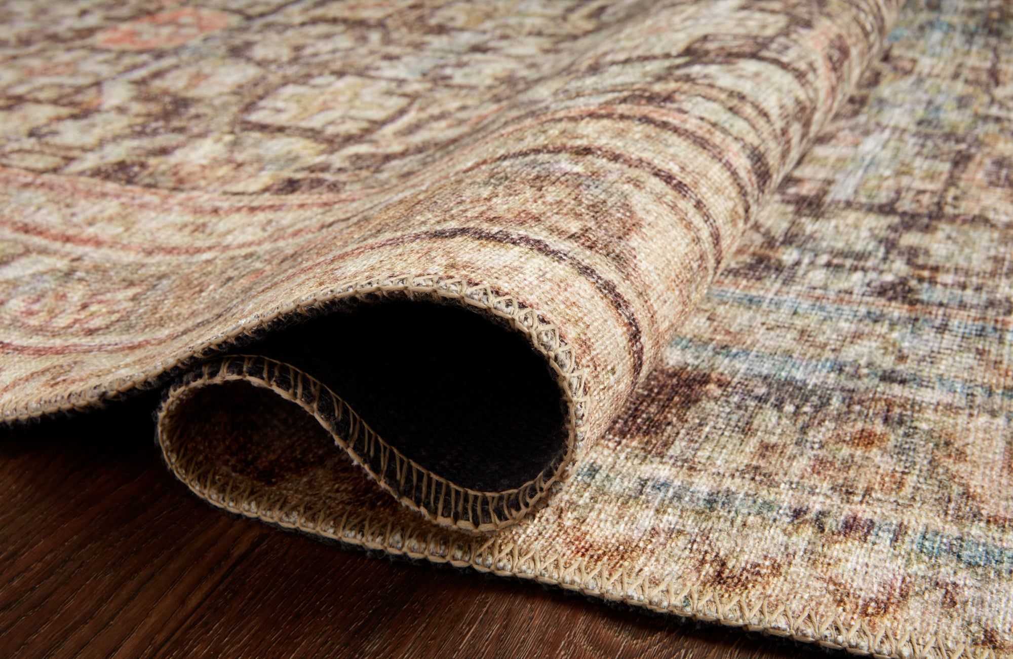 Close-up of patterned polyester outdoor rug with stitched edges, showing soft texture and lasting durability.