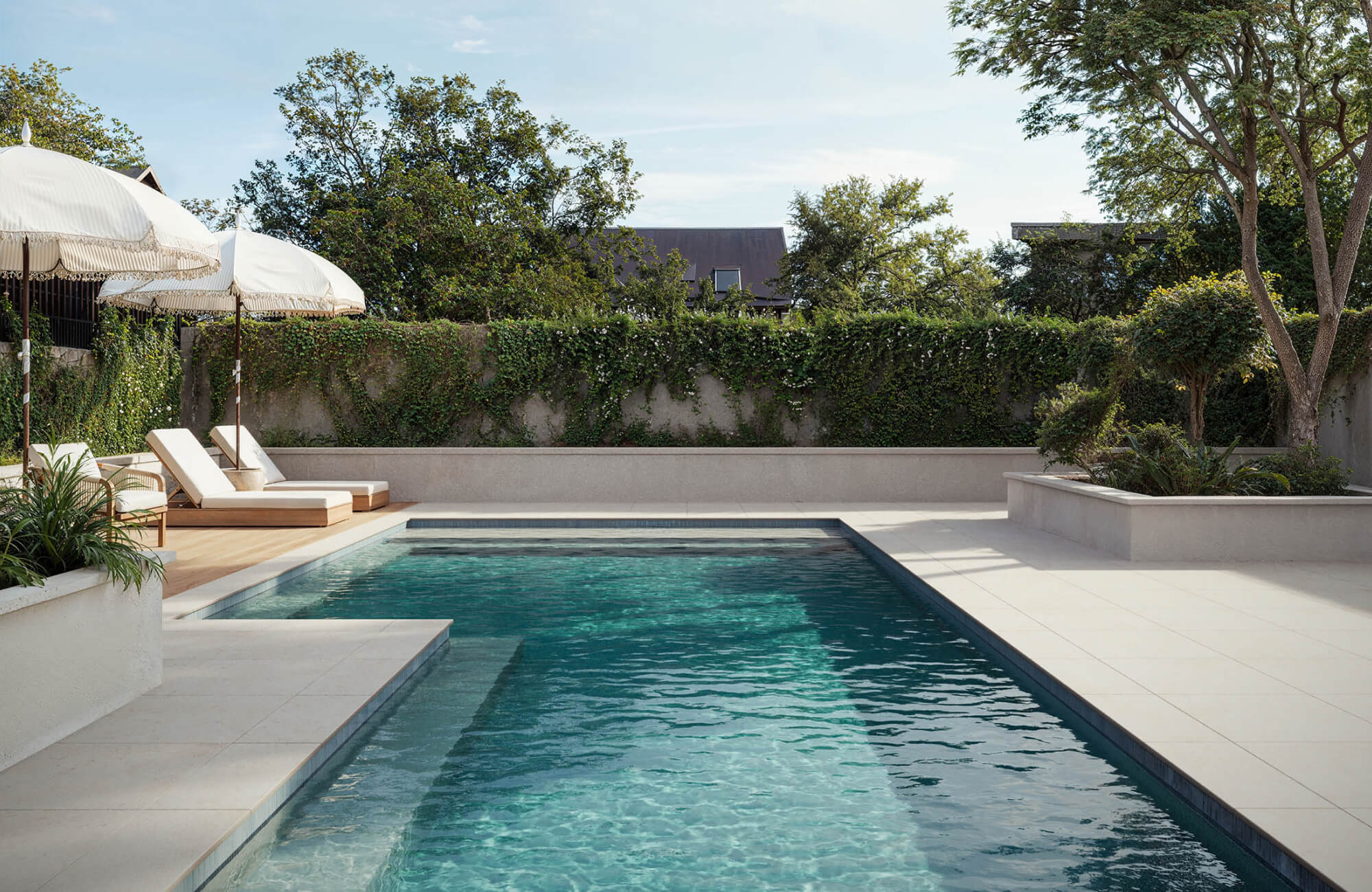 null Poolside outdoor tile installation with light-colored surfaces that reflect sunlight and provide a stable footing around the water’s edge.