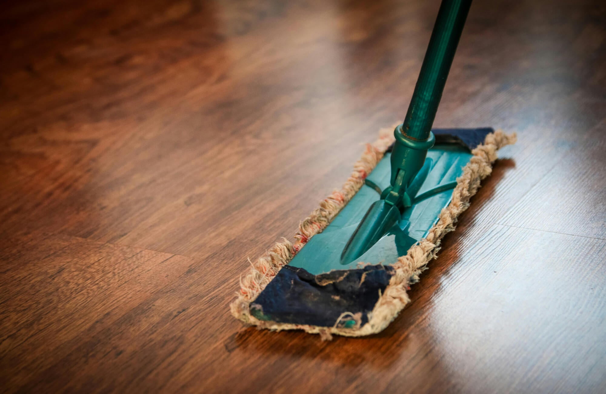null Cleaning hardwood kitchen floor with microfiber mop to maintain shine and durability through regular maintenance and care.