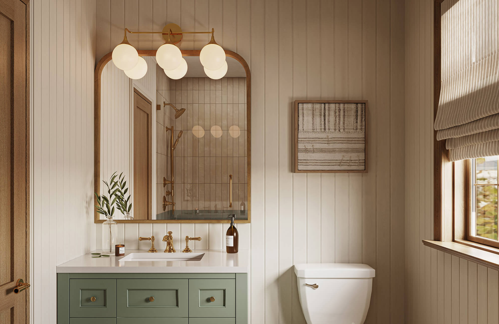 Compact bathroom with vertical wall paneling, a sage green vanity, an arched wood-framed mirror, brass lighting, and neutral abstract wall art above the toilet near a window.