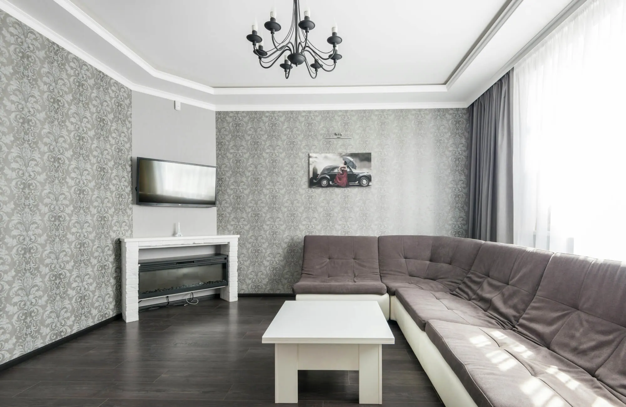 Light gray patterned wallpaper adds subtle elegance and softness to this modern living room with dark flooring.