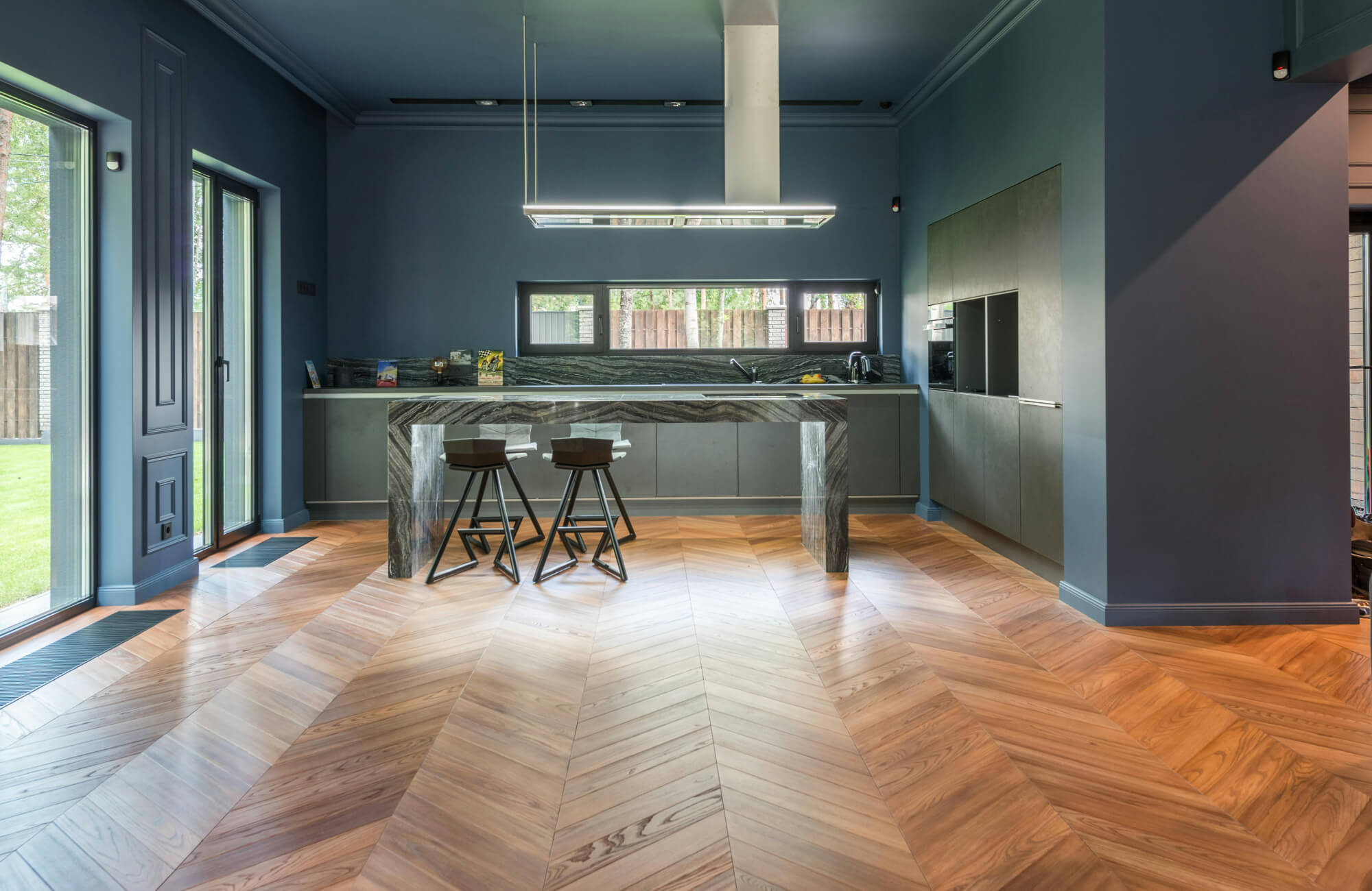 null Contemporary interior featuring luxury vinyl plank floors in a herringbone layout, paired with sleek cabinetry and bold wall color.