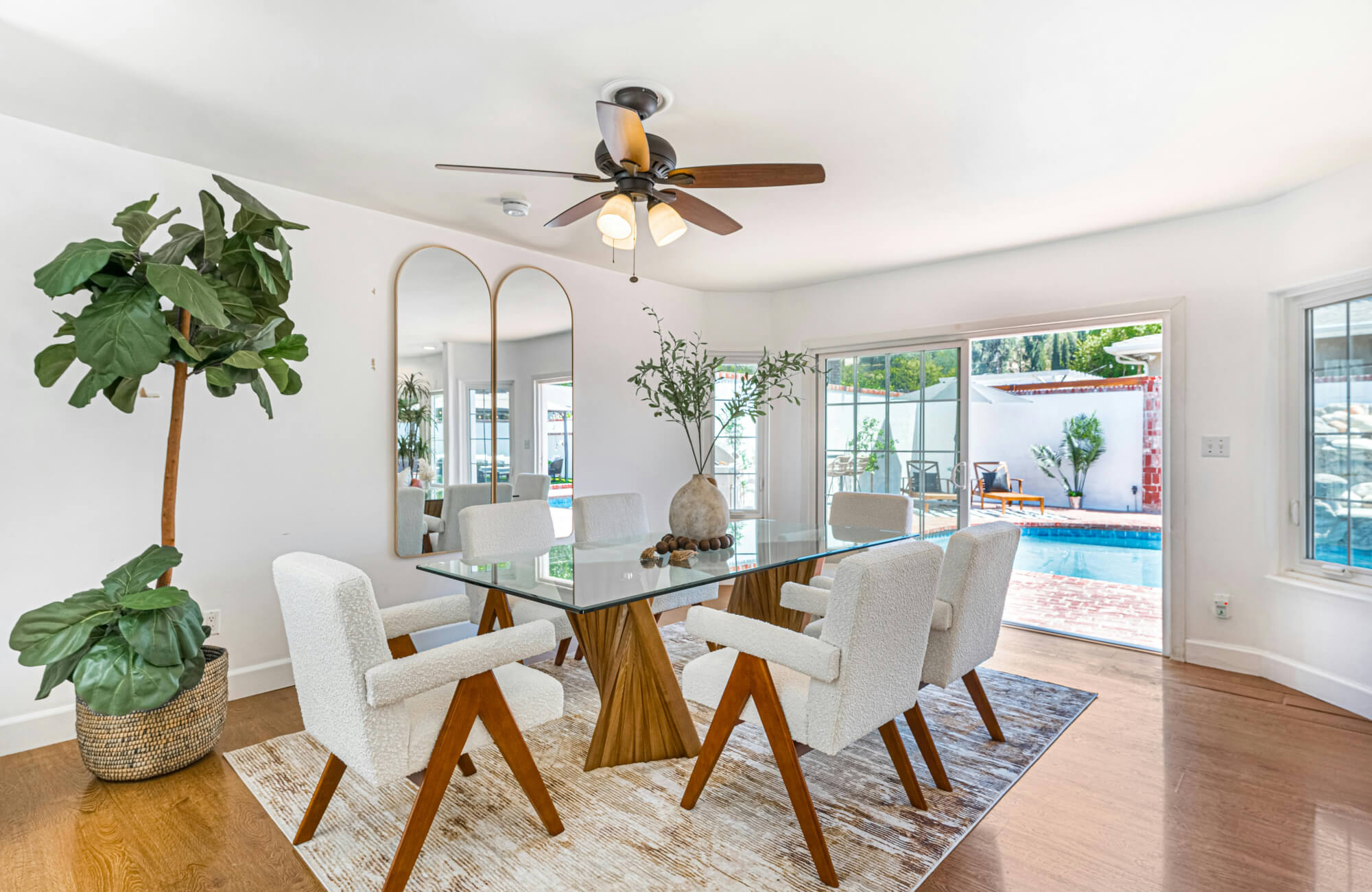 null Tall mirror placed on a dining room wall to reflect light and seating without overpowering the room’s layout.